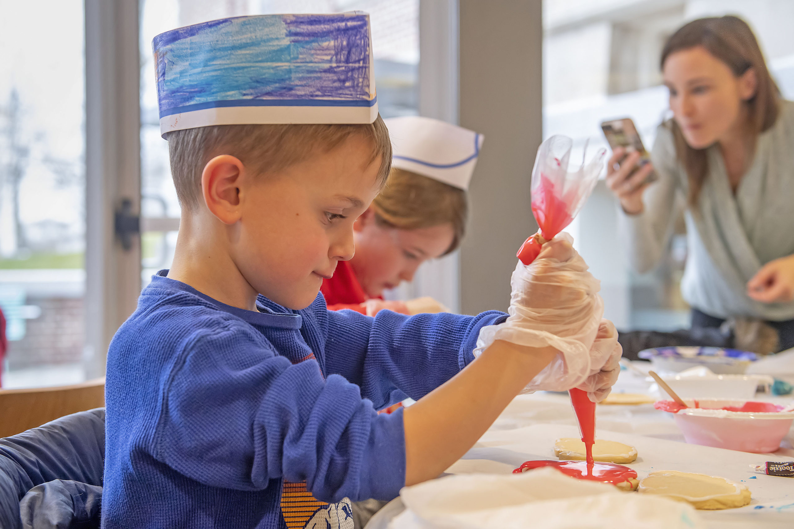 Six-year-old Henry Rozzi is a study in concentration as she applies some icing during a Football Jersey Cookie Decorating Workshop that was held at the John Jermain Library on Saturday.    MICHAEL HELLER