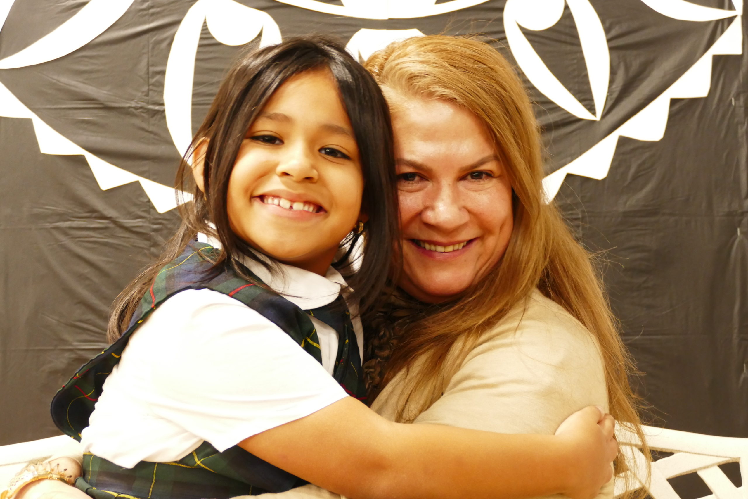 Our Lady of the Hamptons School second-grader Giressy Blandon hugs her grandmother, Blanca Correal during the school's recent celebration of Catholic Schools Week. 