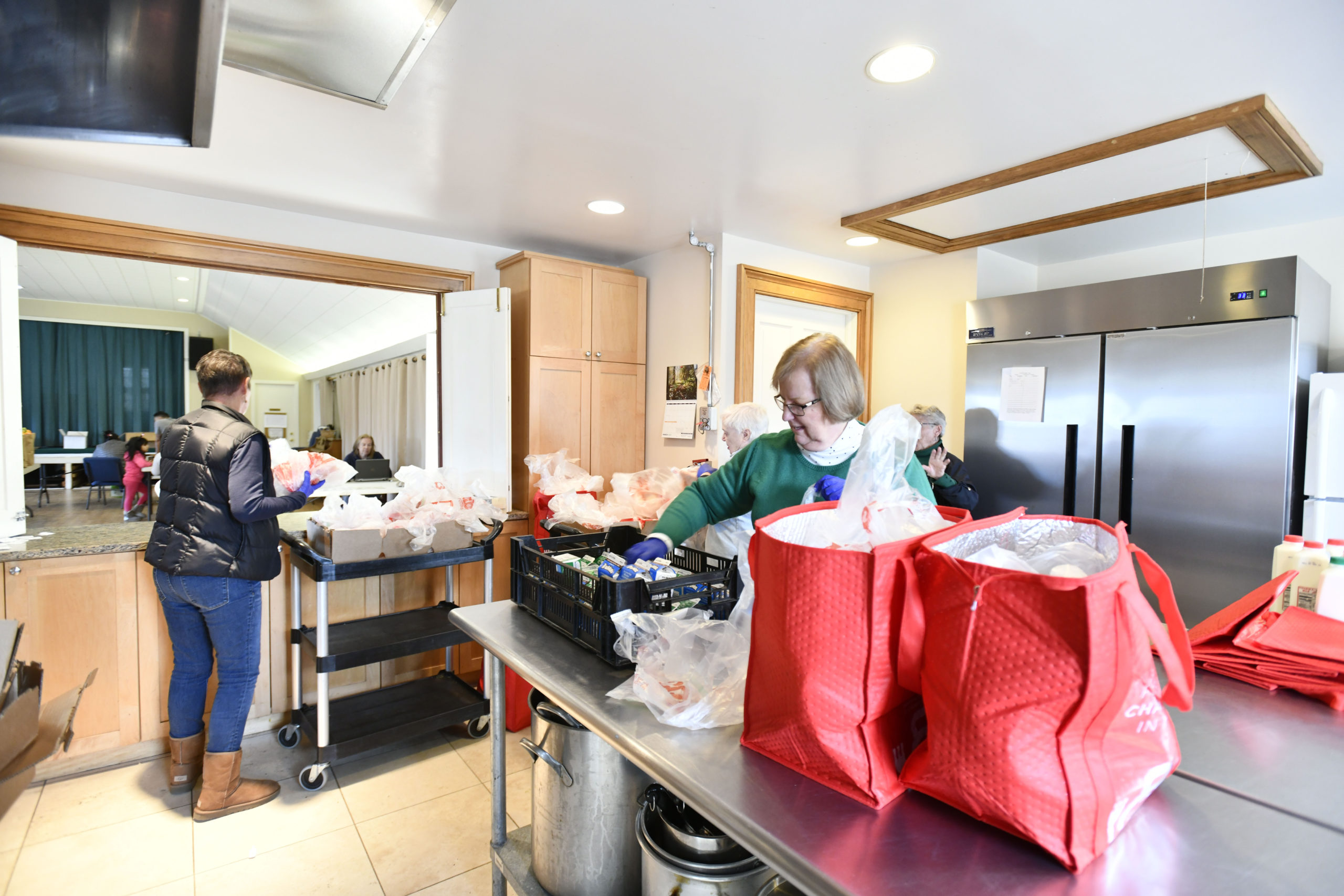 Linda Maconochie, Holly Wheaton and Deanna Tikkanen pack and distribute bags of food at the Springs Food Panrty on Wednesday, March 18.  DANA SHAW