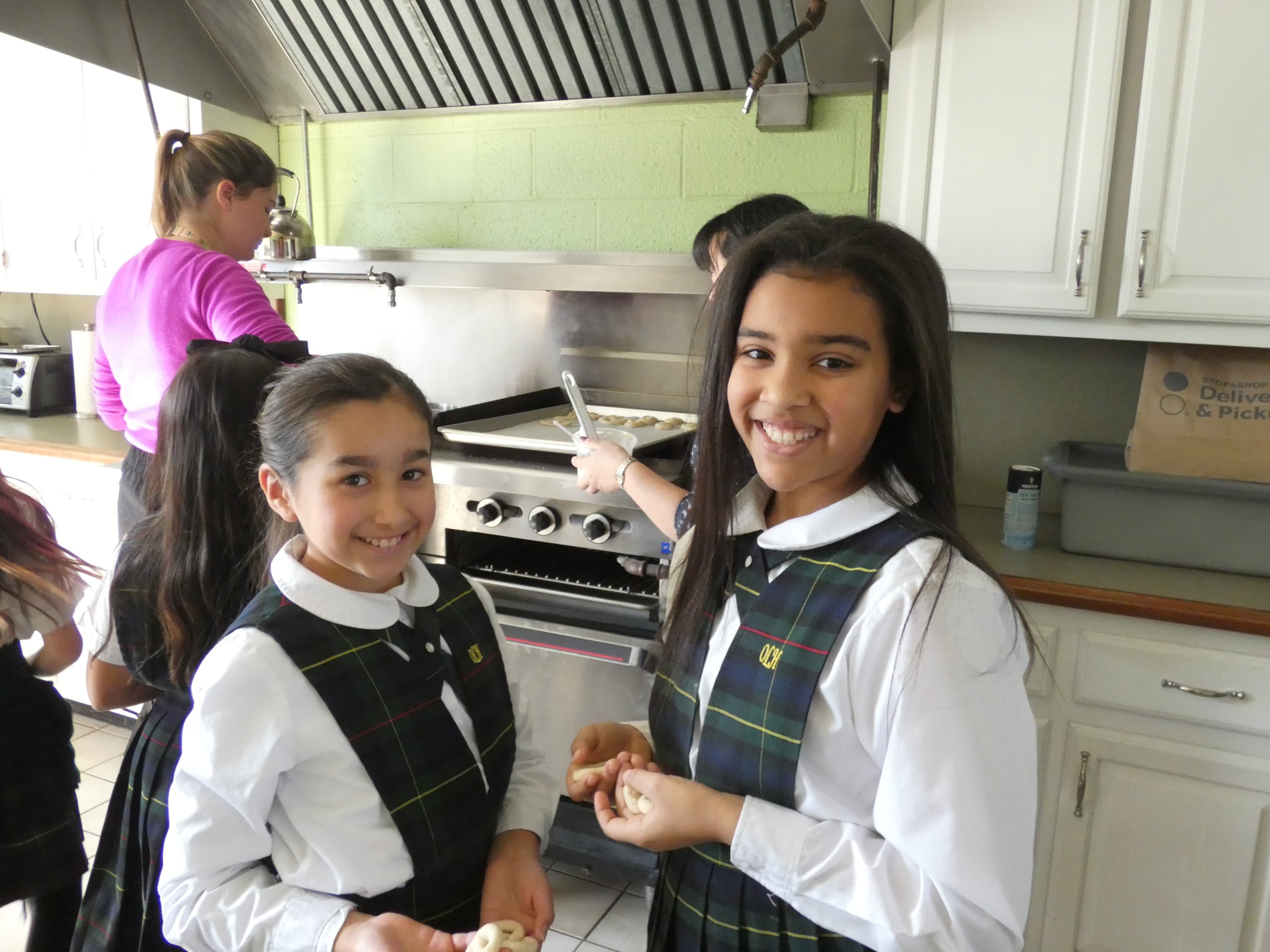 Our Lady of the Hamptons School fourth graders Tsanna Gierra and Aliah Donohoe work on a Lenten pretzel project.