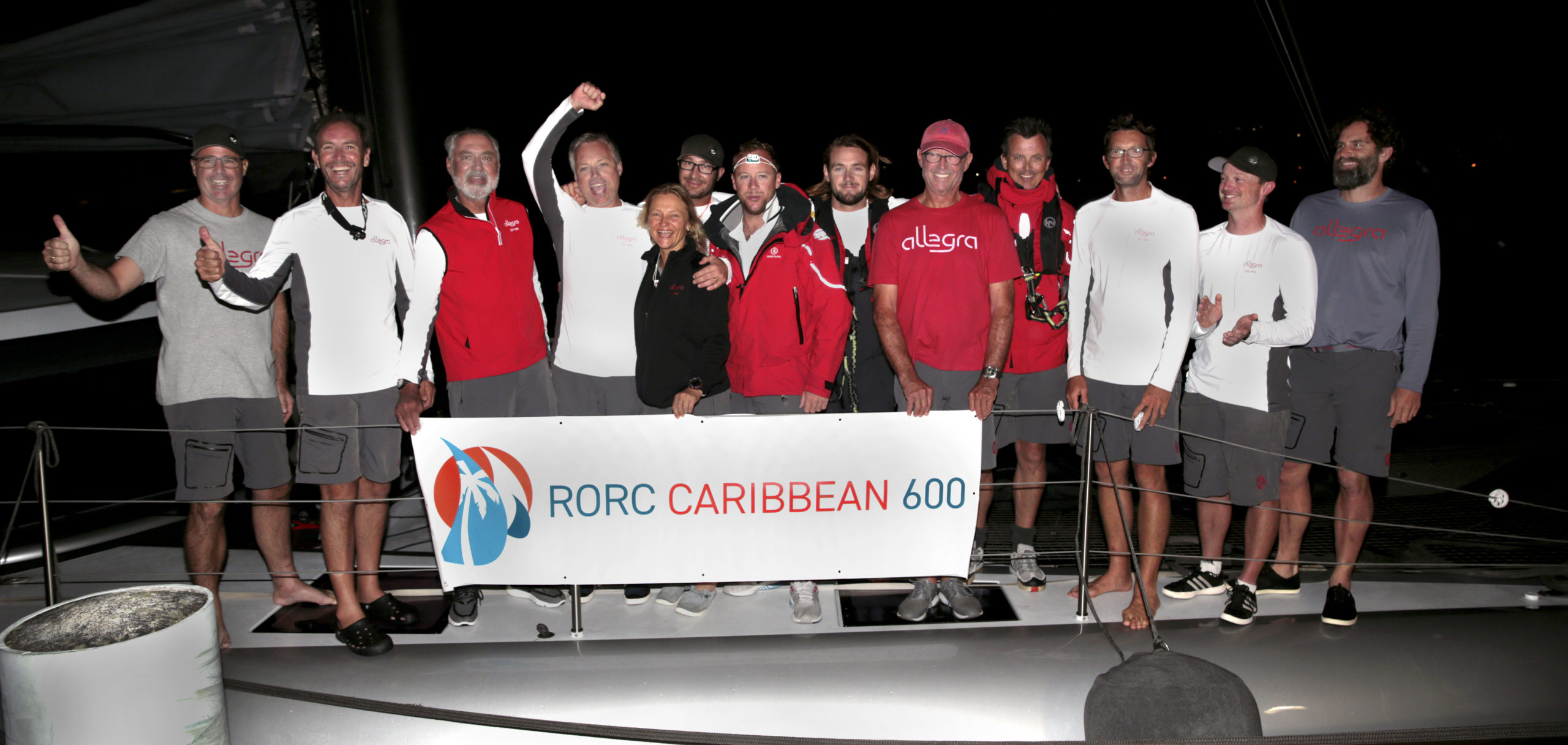 Wainscott’s Adrian Keller, in the red vest, and North Haven's Fred Stelle, in the red shirt, holding the RORC Caribbean 600 banner, along with the rest of their multinational crew.