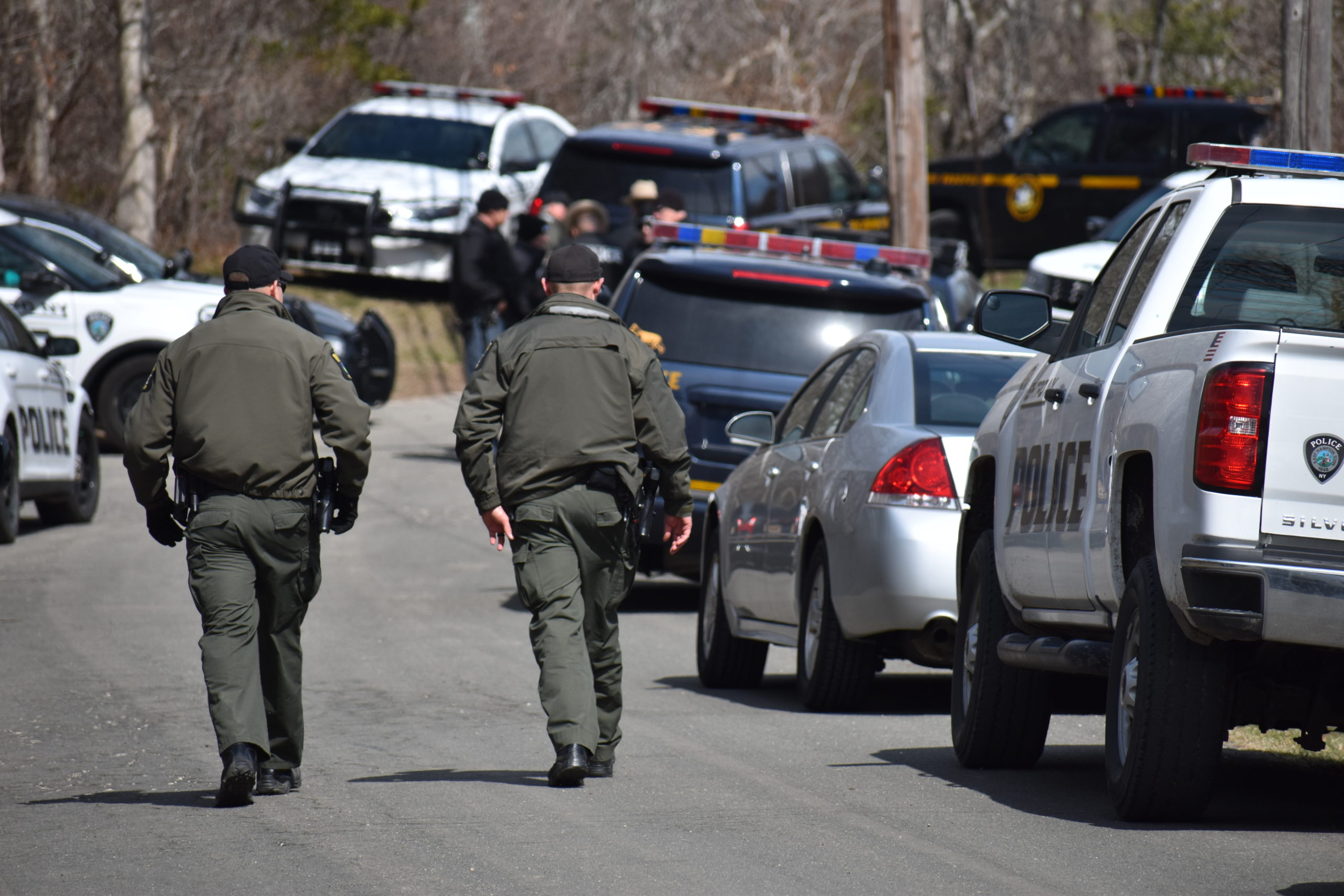 Two police officers return to the search scene near Camp Hero State Park.