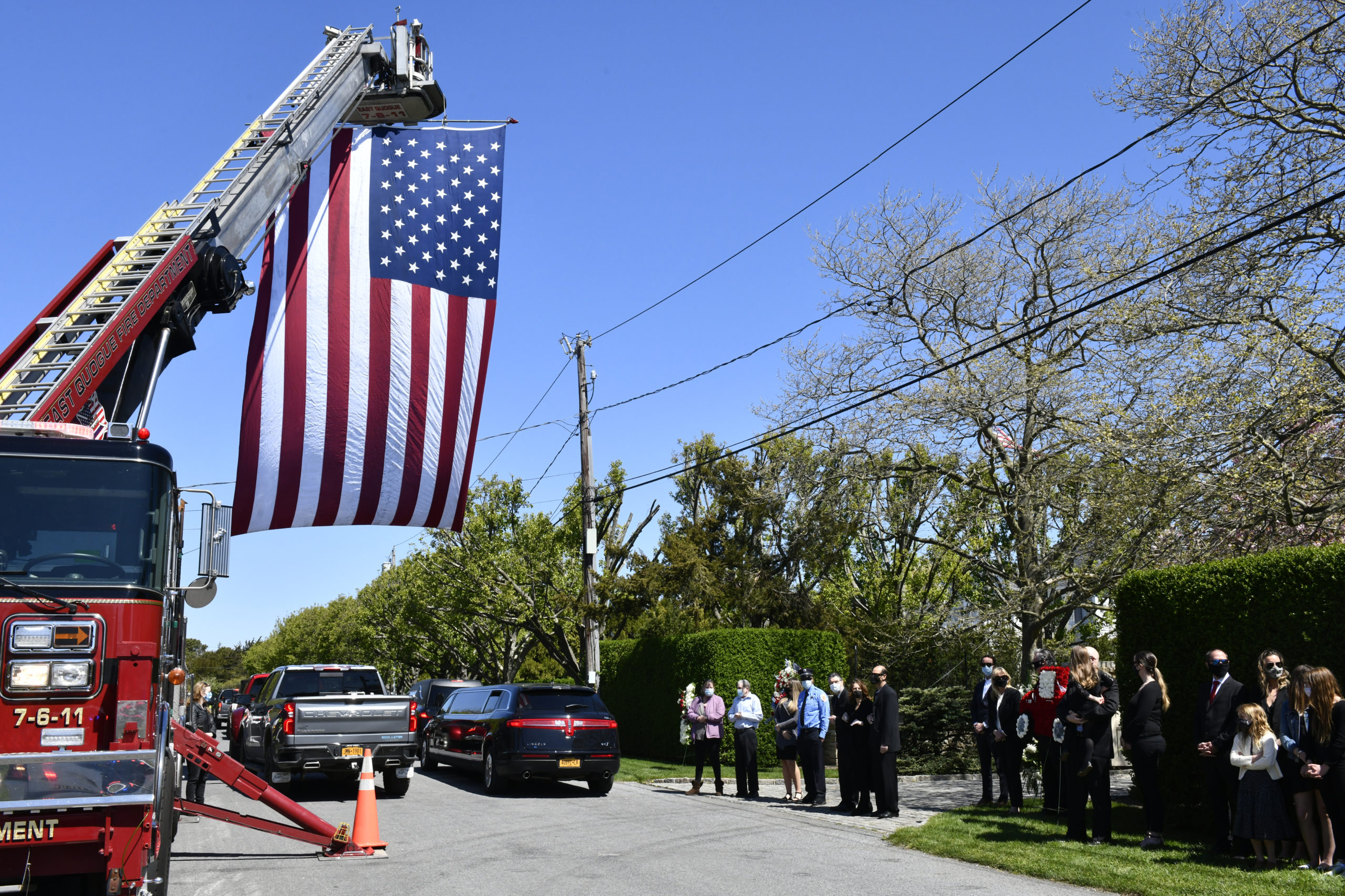 Members of the Quogue Fire Department line street heading to the home of George Mathys on May 13.  DANA SHAW