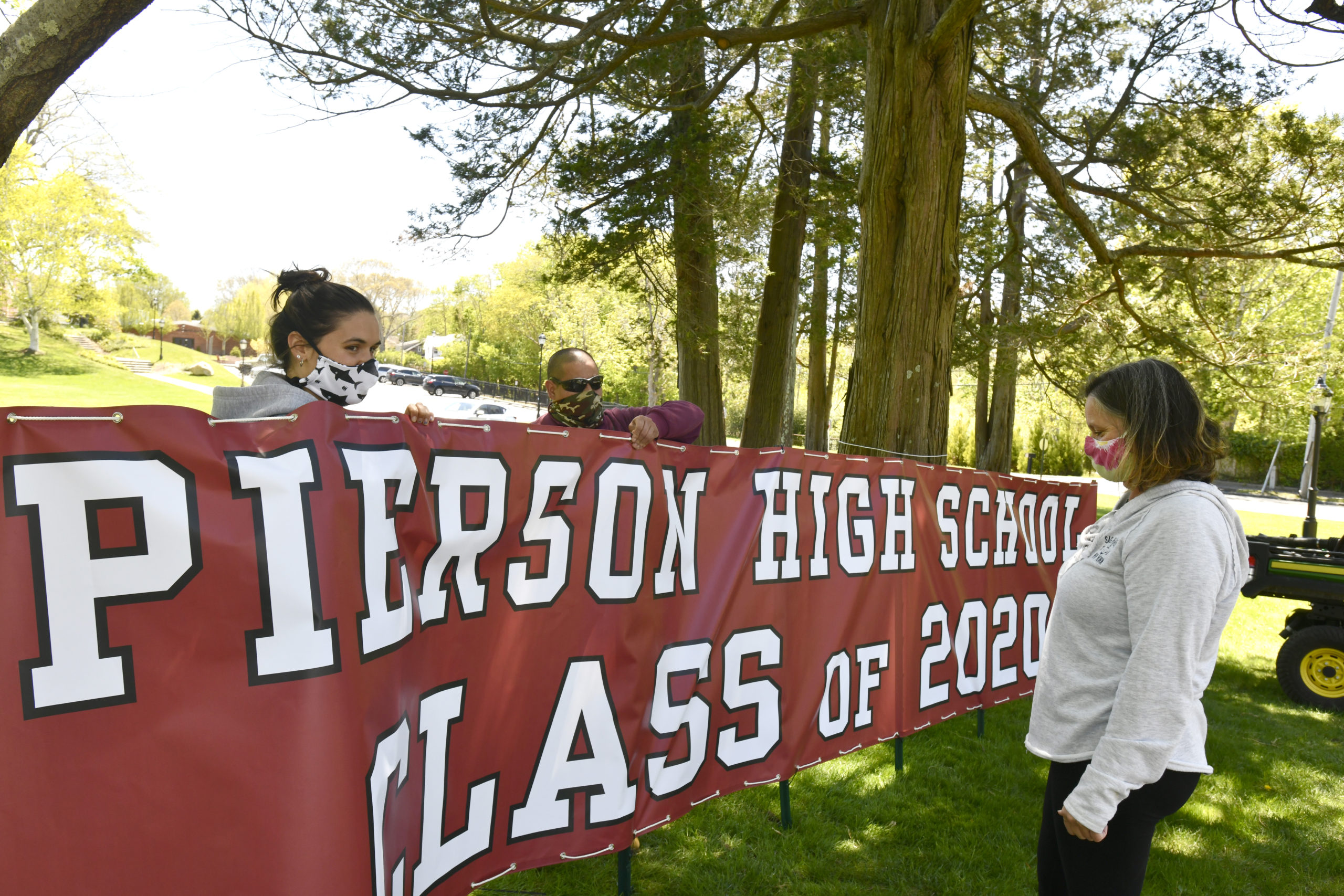 Emiley Nill, Jorge L. Maya and Fran Nill put up the sign at Pierson High School on Wednesday.