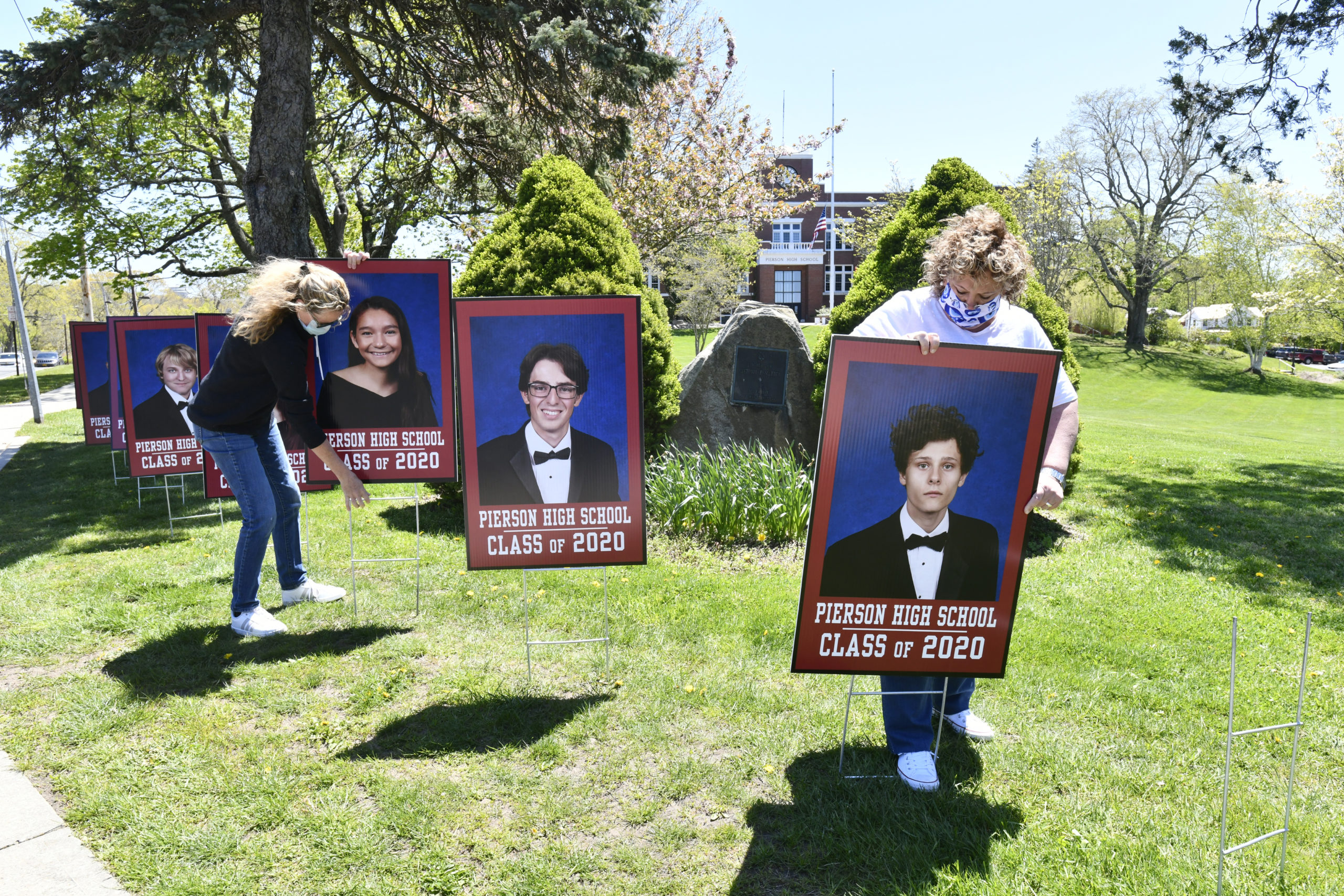 Stephanie Bitis and Pia Ferraris place photos of graduates on Pierson Hill on Wednesday. 