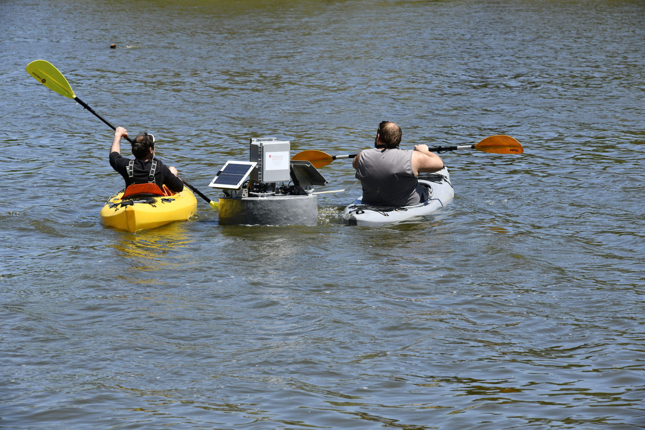 The real-time water quality monitoring buoy  is towed into the middle of Lake Agawam on Friday. DANA SHAW
