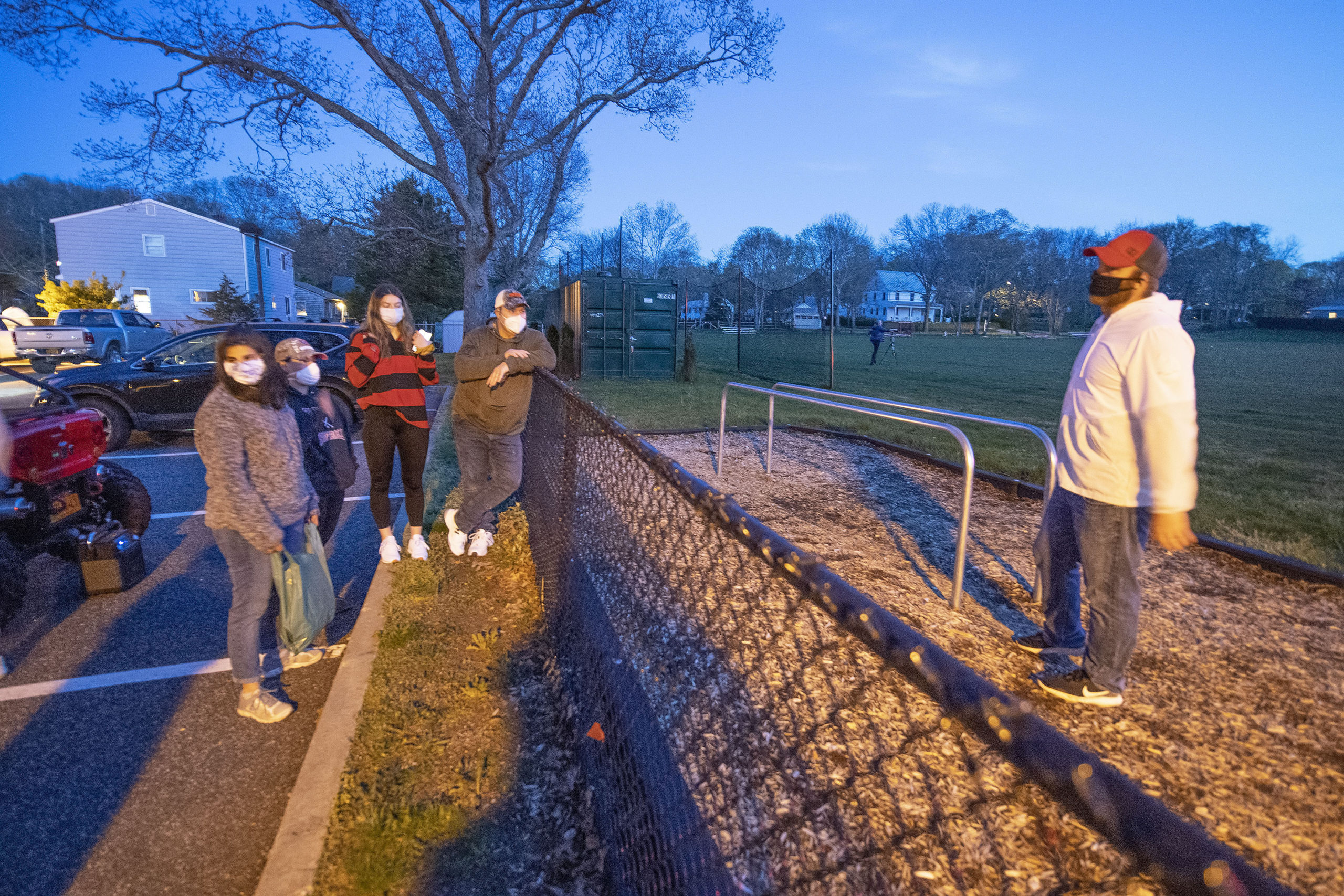 Pierson Athletic Director Eric Bramoff chats with the Arbia family prior to a tribute to the Pierson High School senior athletes in the Montauk Avenue parking lot behind the school on Friday night.