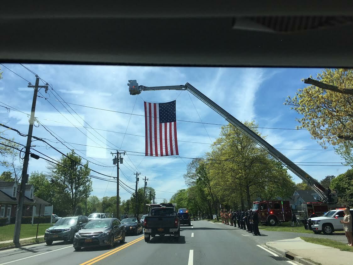 Cranes hoistd flags over Montauk Highway along the funeral procession route. LORI SIDOR