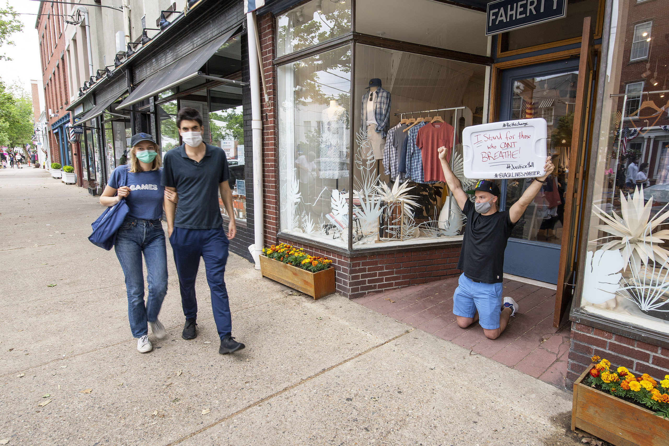 Unable to leave work, Jeremy Impelliveri makes his voice heard from the doorway of the Faherty store as marchers make their way down Main Street during a Black Lives Matter protest rally held in Steinbeck Park on Friday afternoon.    MICHAEL HELLER
