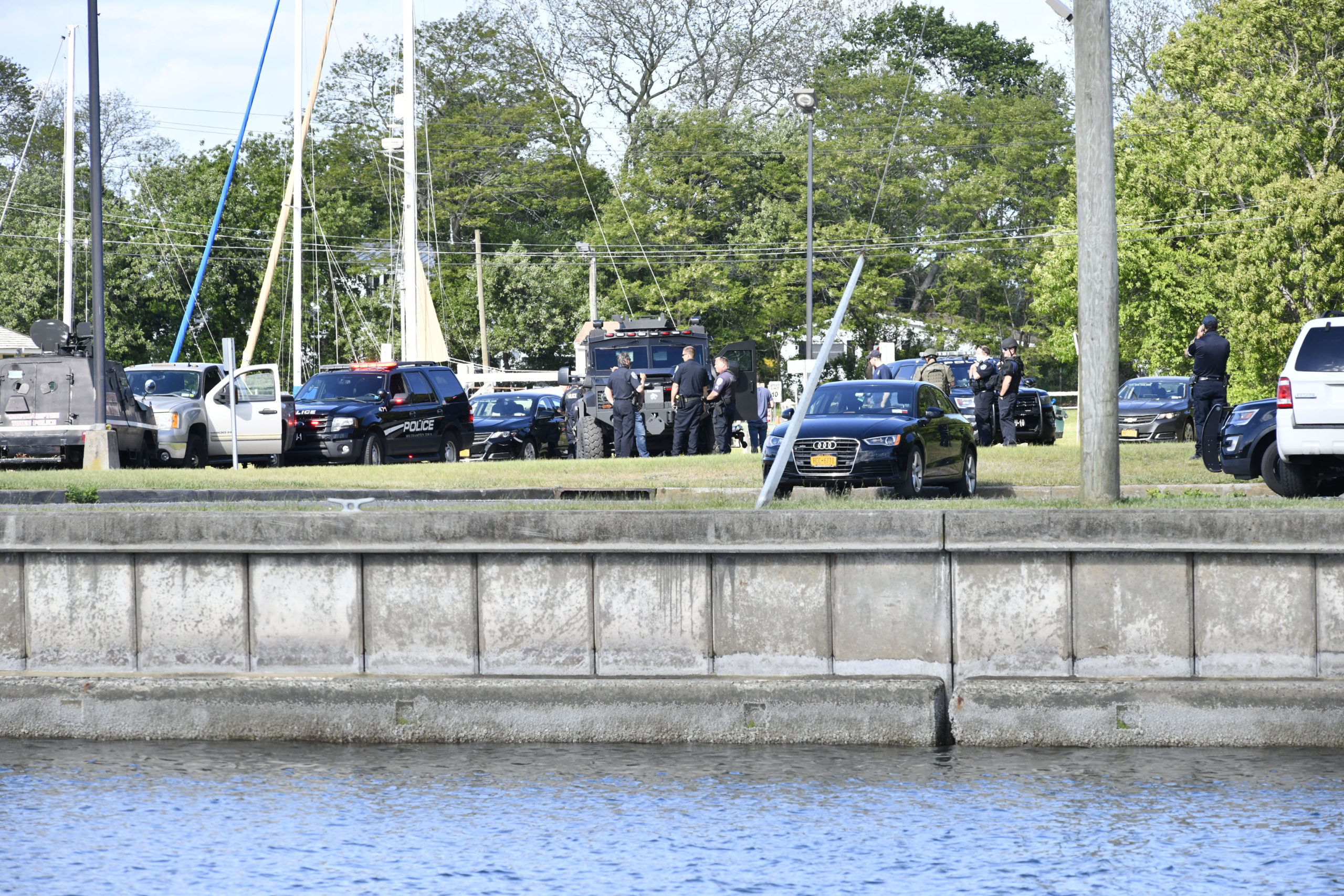 Law enforcement surround a subject with a handgun in the parking lot at  Meschutt Beach in Hampton Bays on Monday afternoon.   DANA SHAW