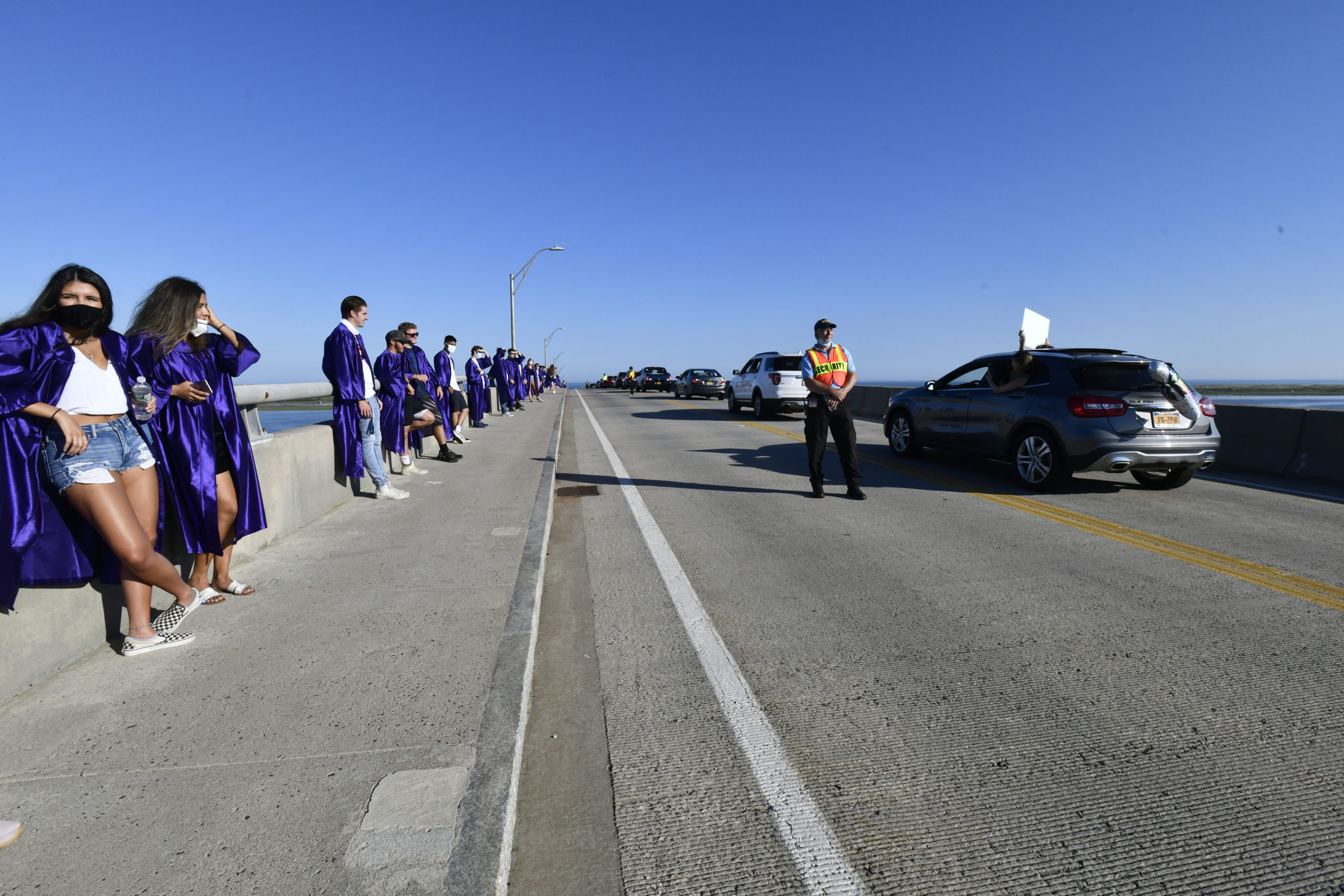 Hampton Bays graduates gathered on the Ponquogue Bridge in Hampton Bays on Monday evening as friends and family drove by to congratulate them.   DANA SHAW