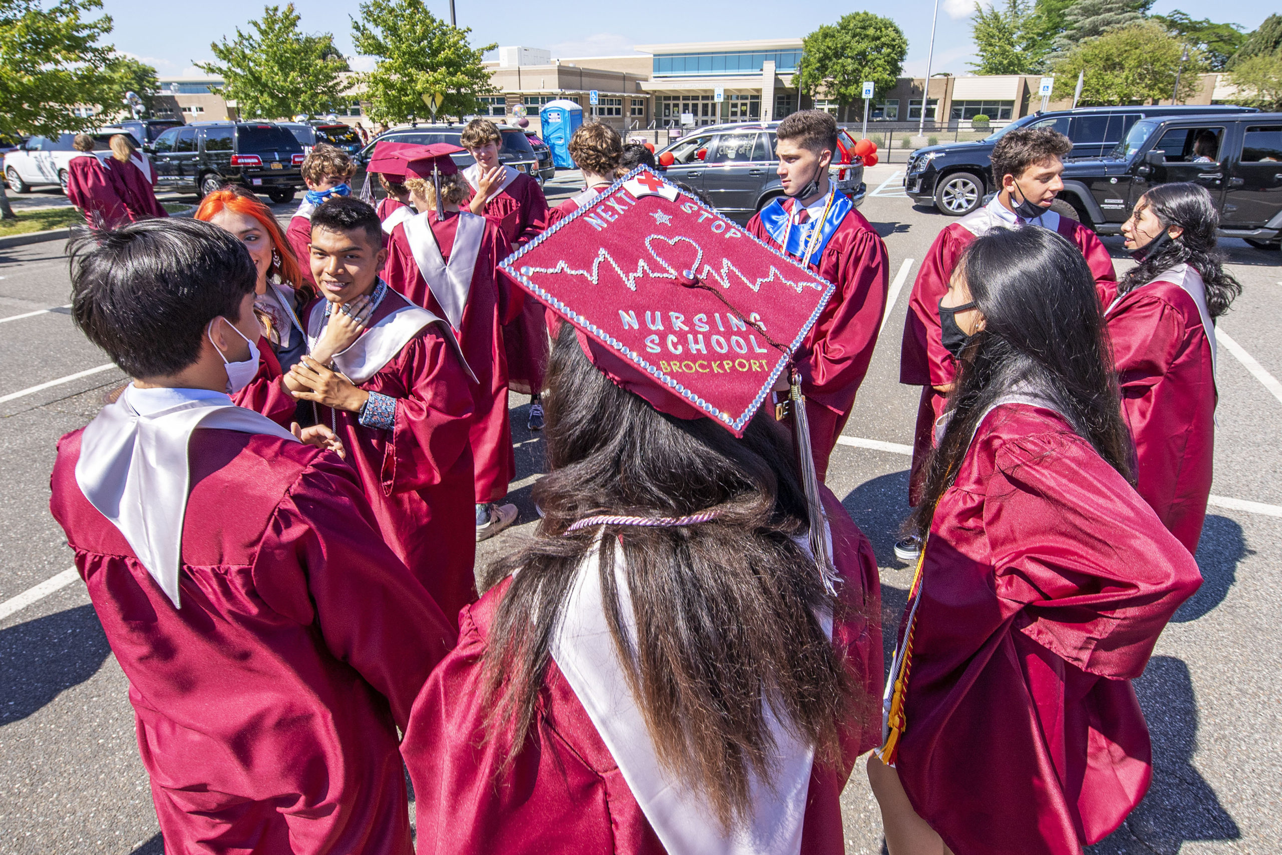 East Hampton High School Senior Tia Weiss proudly shows off her next stop as she greets her classmates in the parking lot as she gets ready to participate in the 2020 graduation ceremony at the East Hampton High School on Friday.