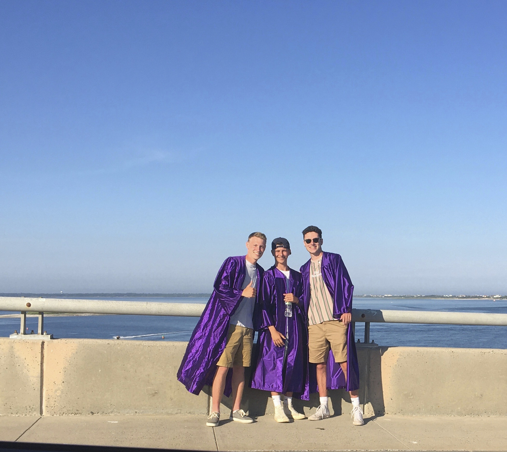 Hampton Bays graduates gathered on the Ponquogue Bridge in Hampton Bays on Monday evening as friends and family drove by to congratulate them. MONICA HANES