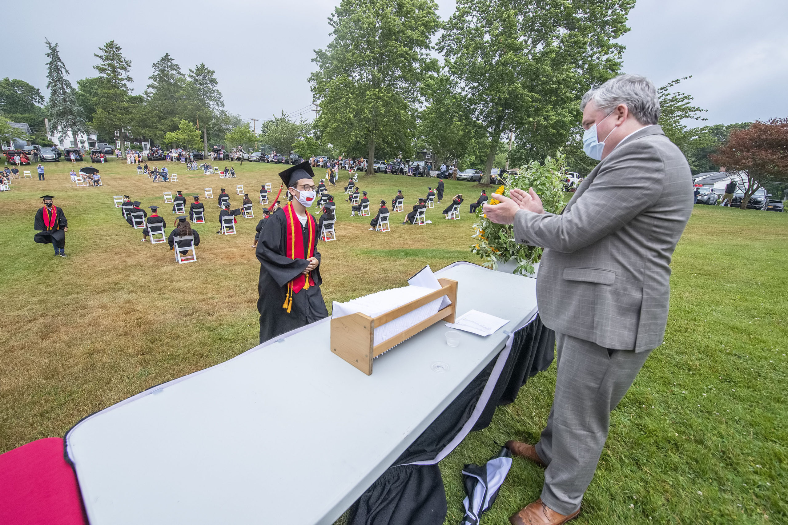 Pierson High School Assistant Principal Mike Guinan applauds Yanni Bitis as he steps up to take his diploma during the Pierson High School 2020 Commencement Ceremony at Pierson High School on Saturday.