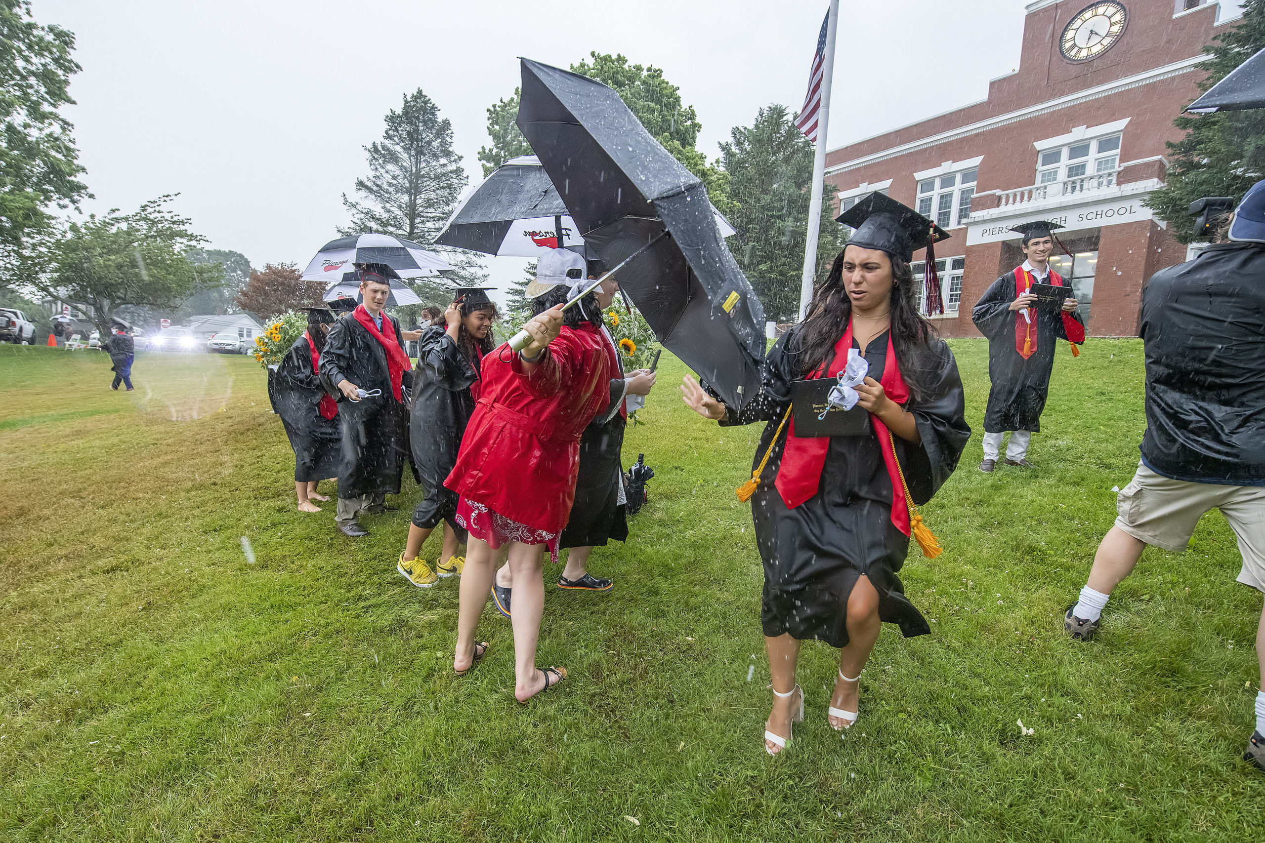 Senior Carly Gulotta rushes to get back to her seat after receiving her diploma and being photographed amidst the scramble in the pouring rain during the Pierson High School 2020 Commencement Ceremony at Pierson High School on Saturday.