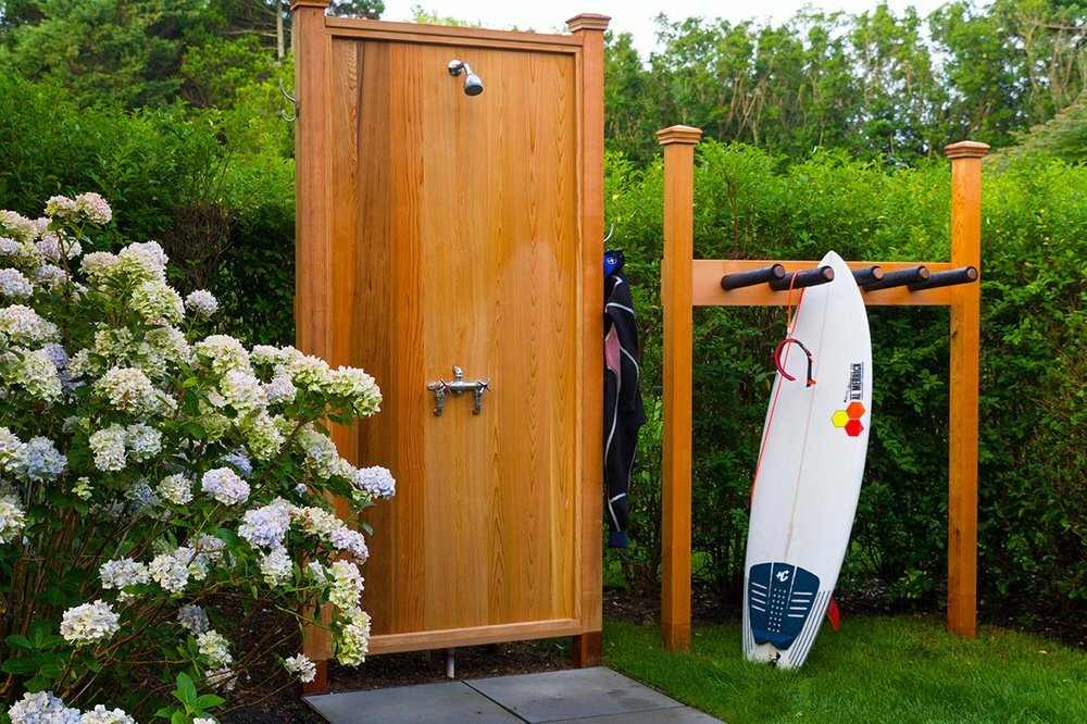 An outdoor shower with natural screening designed by Gardeneering Landscapes.