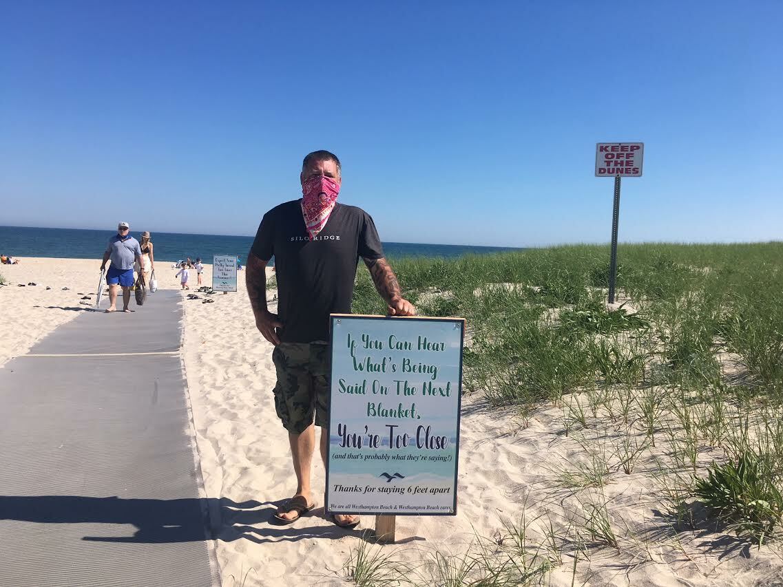 The sign warns visitors to maintain social distance. Westhampton Beach Village Board member Brian Tymann creidts colleague, Mayor Maria Moore, with coming up with the catchy verbiage.  KITTY MERRILL