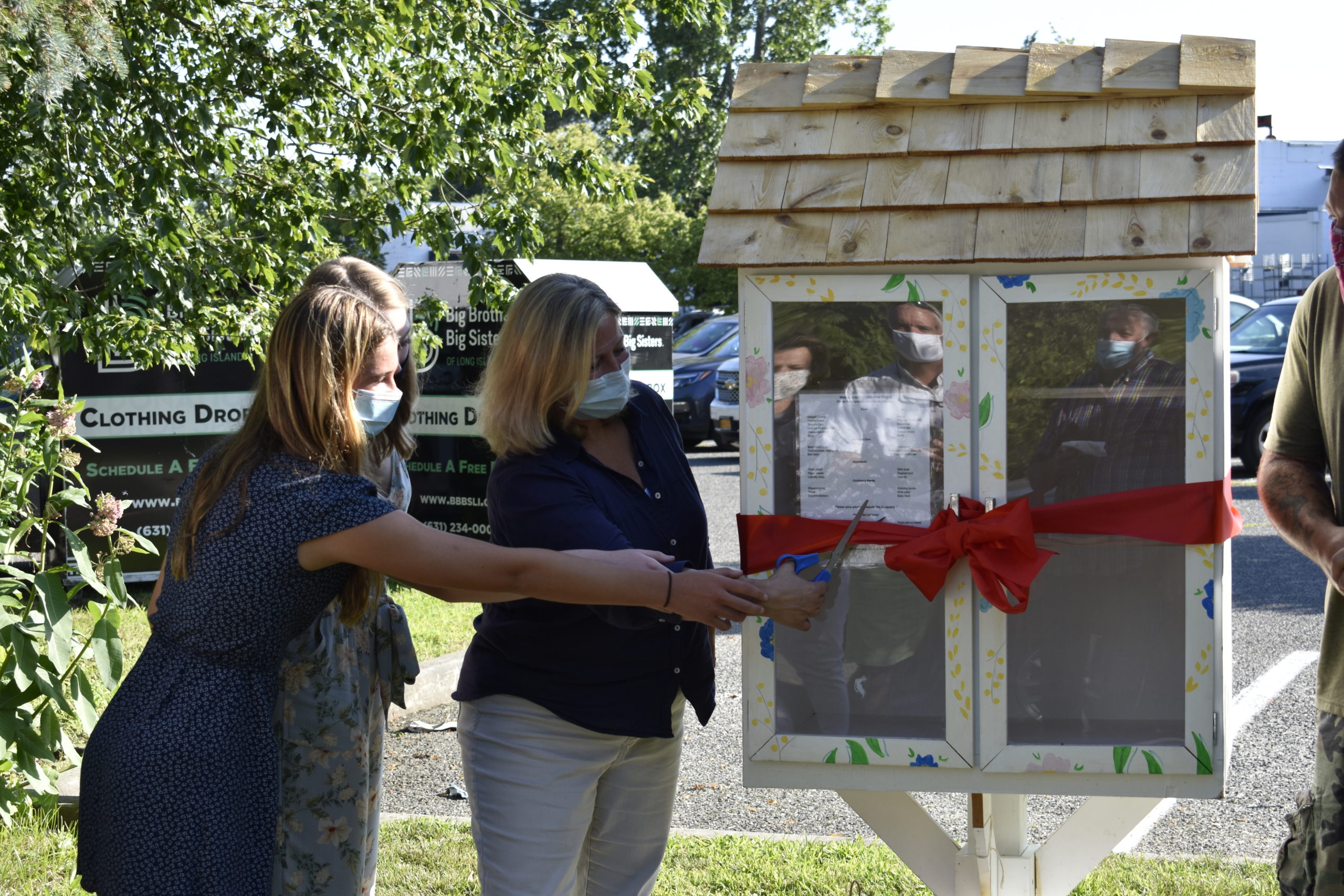 Westhampton Beach Village Mayor Maria Moore and Westhampton Beach High School students Fainne Sheehan and Alie Fitt cut the ribbon on the new Little Free Pantry.