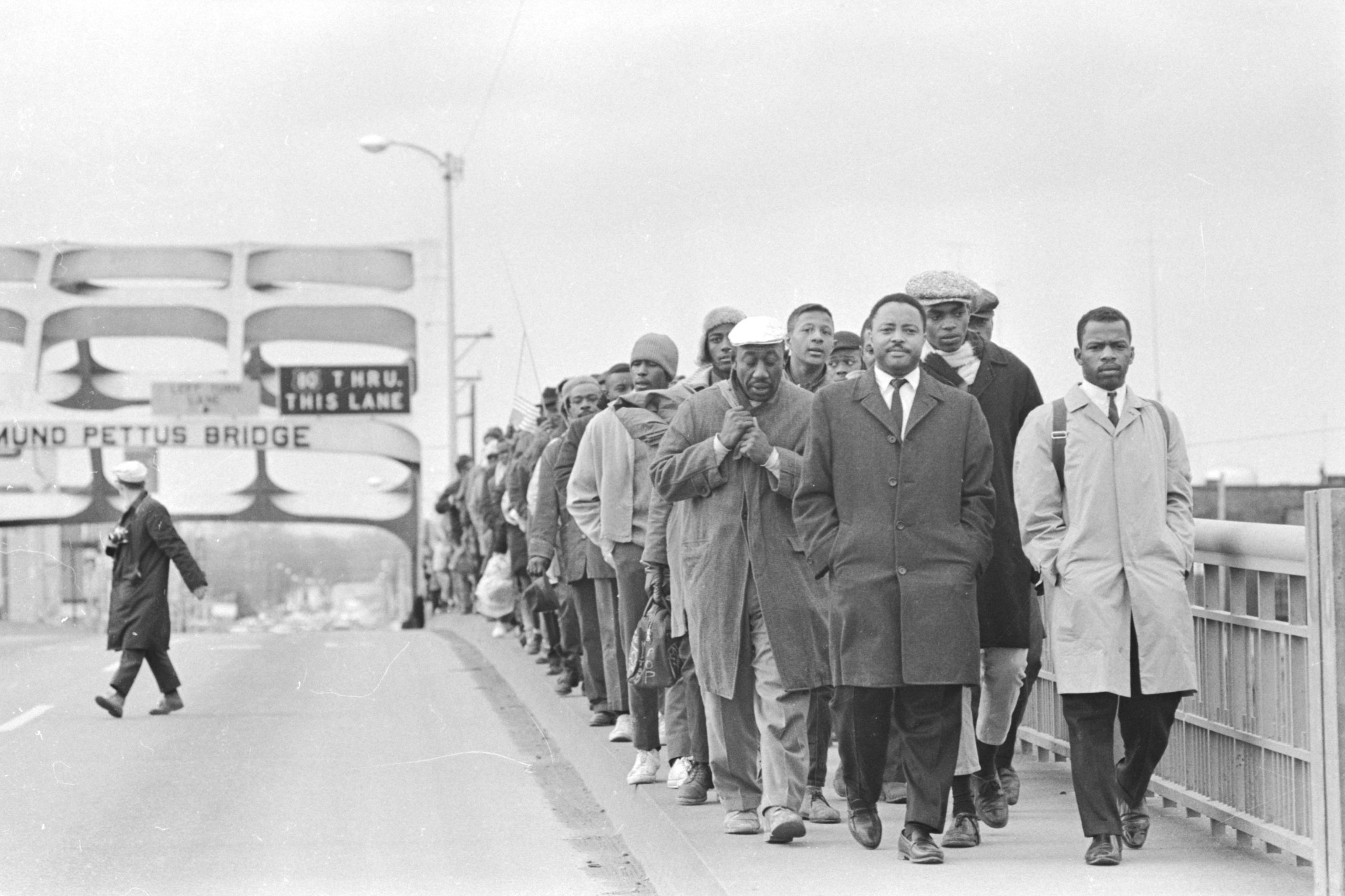 John Lewis with fellow protesters at Edmund Pettus Bridge, in “John Lewis: Good Trouble,” a Magnolia Pictures release. © Alabama Department of Archives and History. Donated by Alabama Media Group. Photo by Tom Lankford, Birmingham News.
