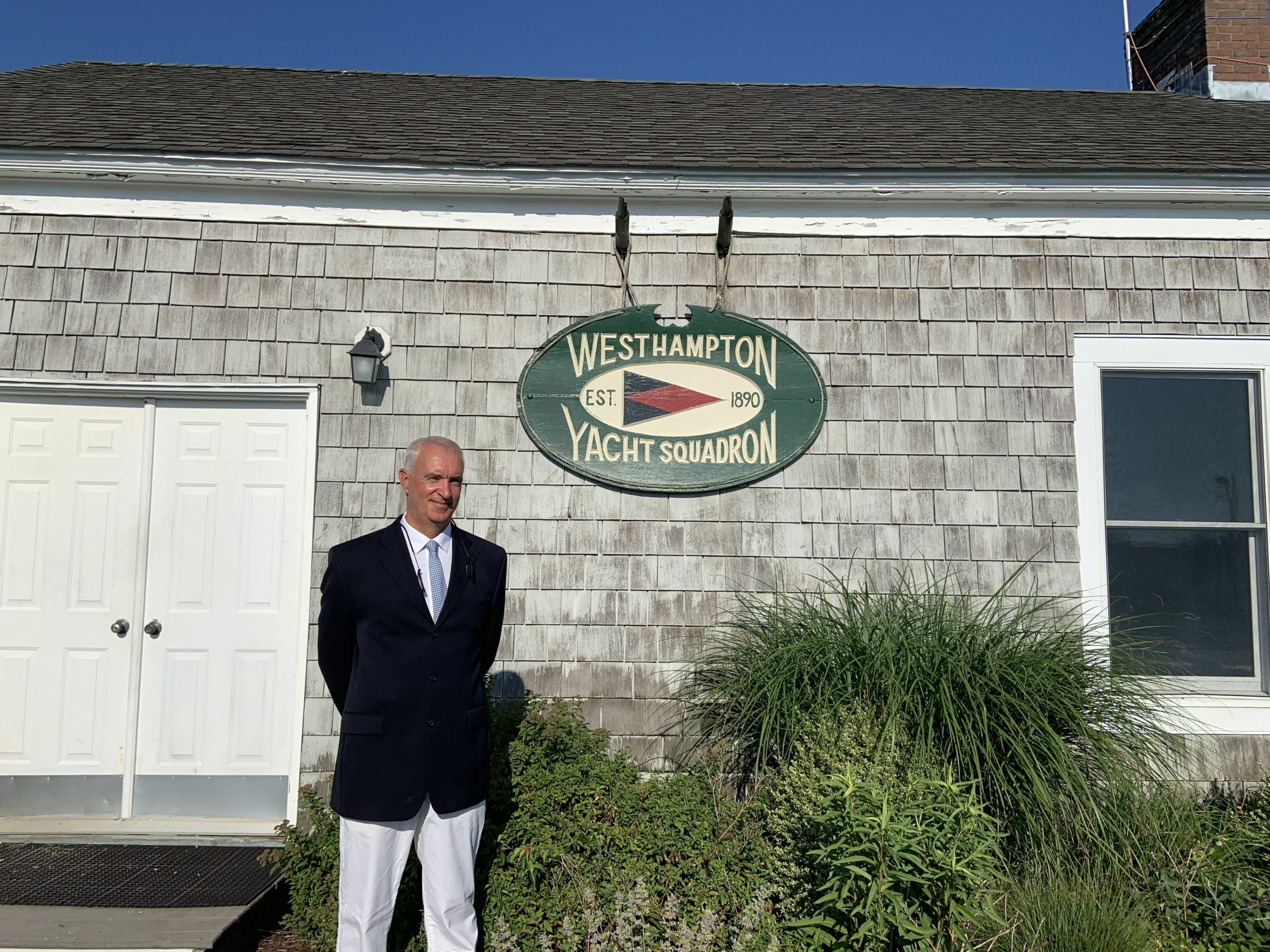 Commodore J.M. Sheehan in front of the original clubhouse signage.