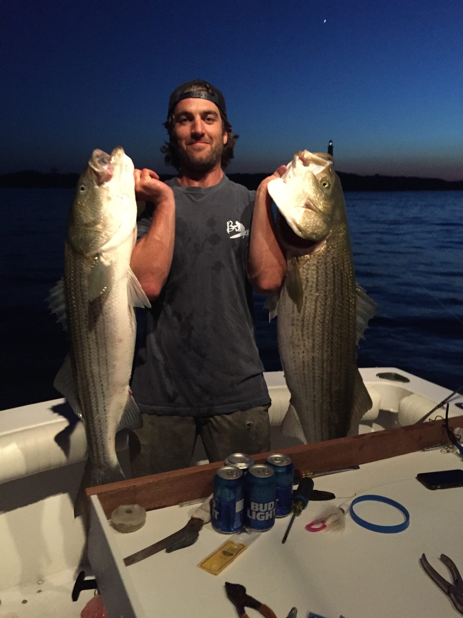 Joe Judge hefts a pair of big striped bass caught as darkness fell over Montauk Point recently.