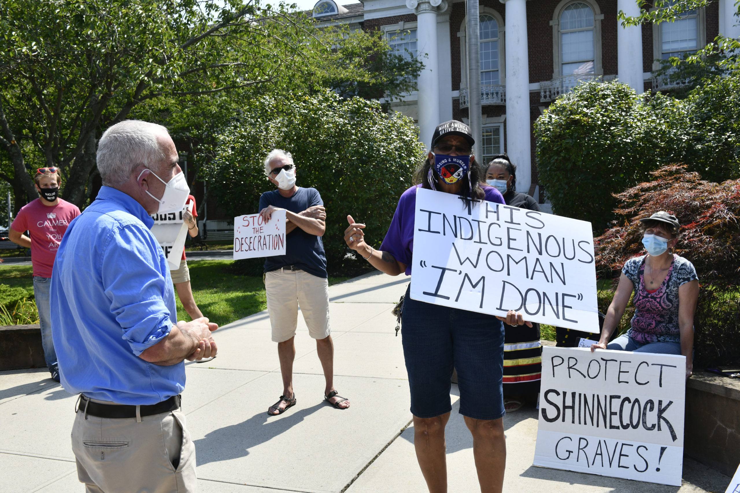 Jennifer E. Cuffee-Wilson of the Shinnecock Nation confront Southampton Town Supervisor Jay Schneiderman about the protection of Shinnecock burial sites at a protest on Tuesday afternoon.  DANA SHAW