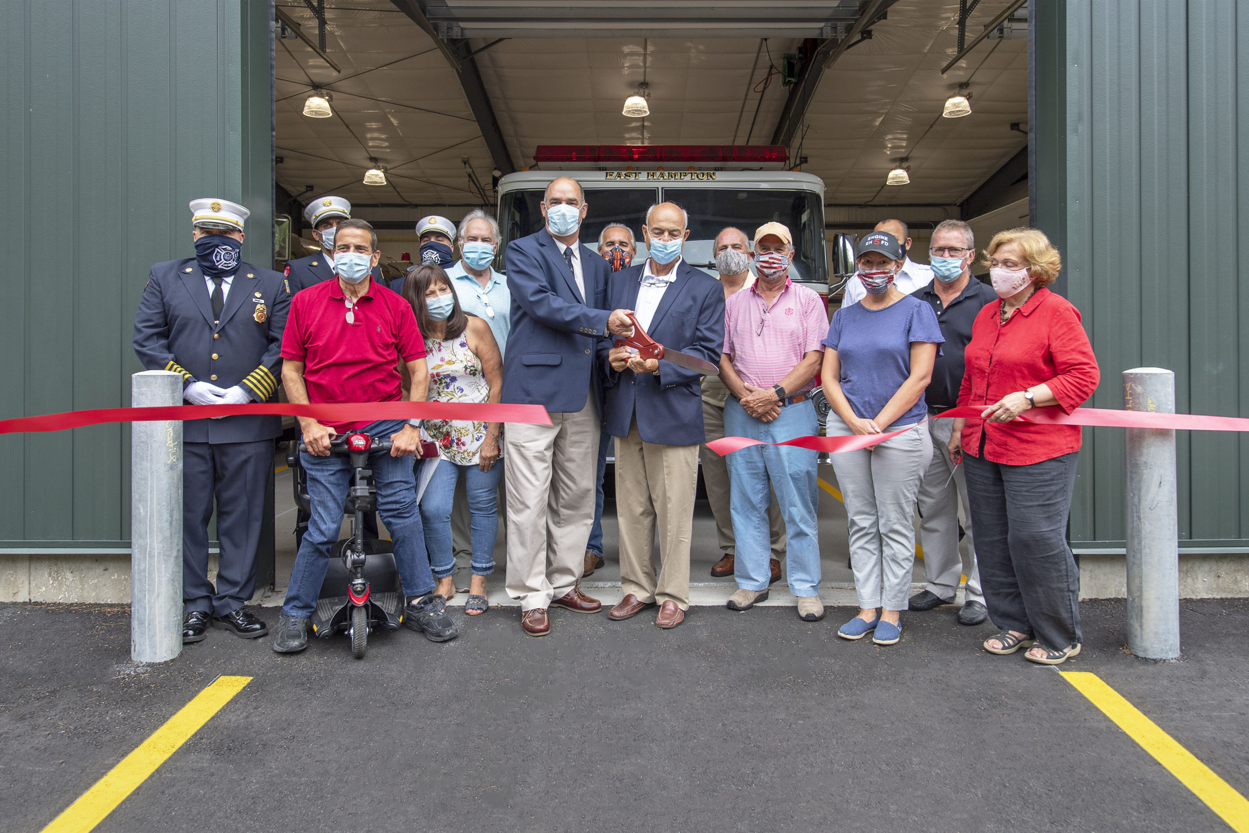 East Hampton Town Supervisor Peter Van Scoyoc and East Hampton Village Deputy Mayor Rick Lawler cut the ribbon during the ribbon-cutting ceremony for the new East Hampton Fire Department substation at 18 Old Northwest Road on Friday.   MICHAEL HELLER