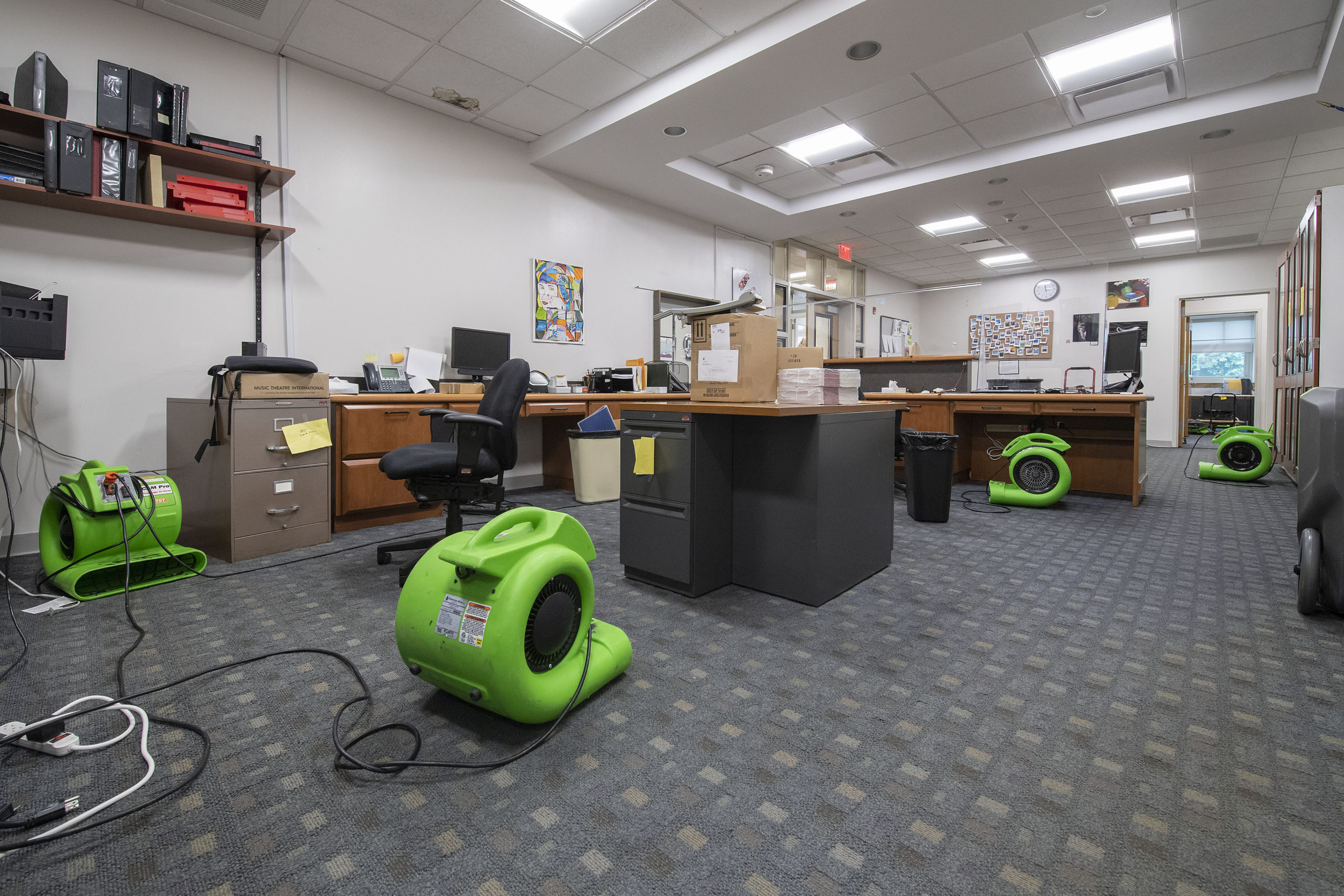 Fans have been placed throughout the East Hampton School District's administrative offices to help dry the carpet, which was flooded when a water pipe burst over the weekend. MICHAEL HELLER
