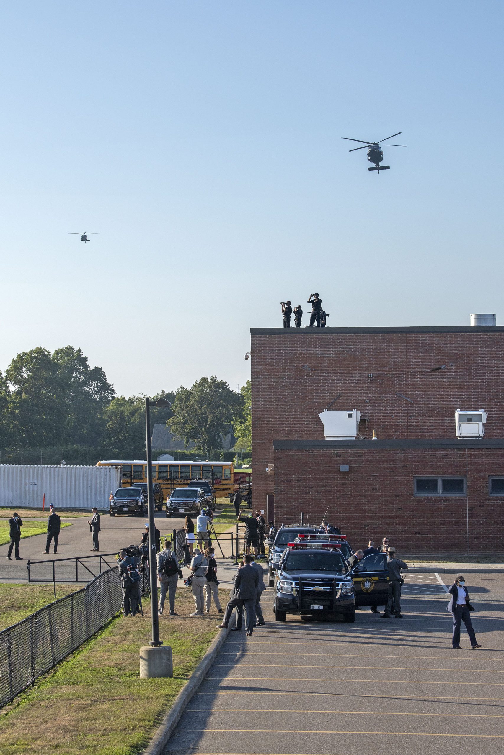 The presidential motorcade awaits as helicopters approach for a landing. Members of the Southampton Fire Department went on standby to provide fire protection as President Donald Trump arrived at the athletic fields behind Southampton High School during his visit to the Hamptons on Saturday.    MICHAEL HELLER