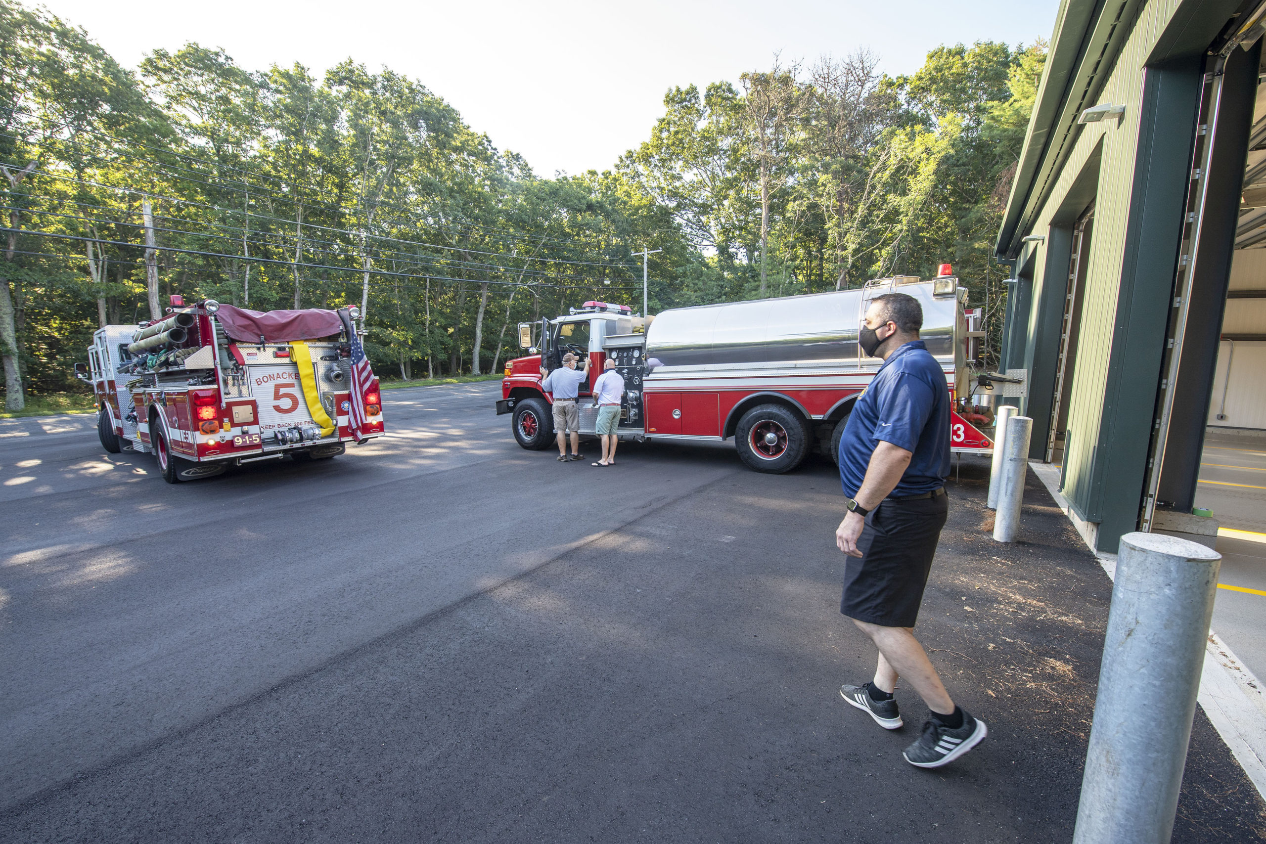 East Hampton Fire Department First Assistant Chief Duane Forrester helps guide Engine 9-1-5 into place as East Hampton Fire Department trucks 9-1-5, 9-1-10 and 9-1-13 are moved into the brand new EHFD Substation on Old Northwest Road on Saturday.   MICHAEL HELLER