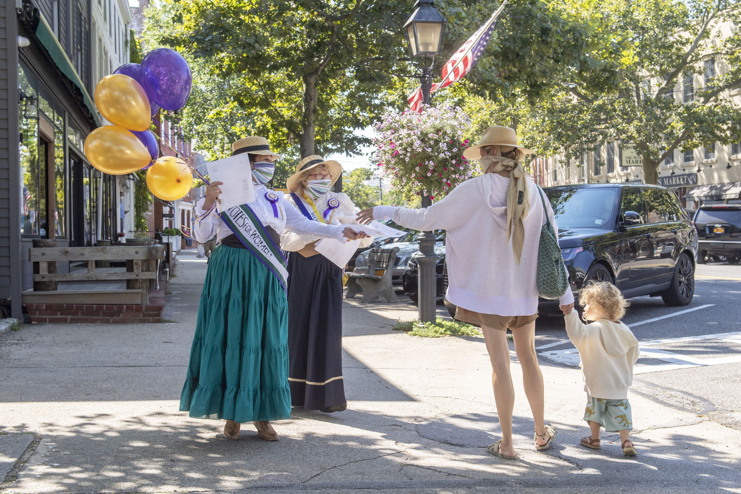 To honor the 100th anniversary of the 19th Amendment and women's right to vote, WLNG radio personality Bonnie Grice and Christ Episcopal Church Pastor Karen Campbell, in conjunction with the Sag Harbor Historical Society, wear period outfits and hand out fliers on Main Street in Sag Harbor on August 26.      
MICHAEL HELLER