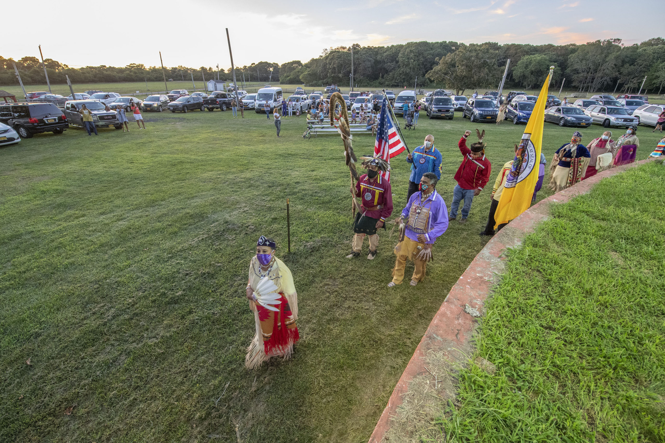 Closed to the public, residents of the Shinnecock Indian Nation watch the opening ceremony of the 74th annual Shinnecock Indian Powwow from their cars and a small grandstand on Friday night.