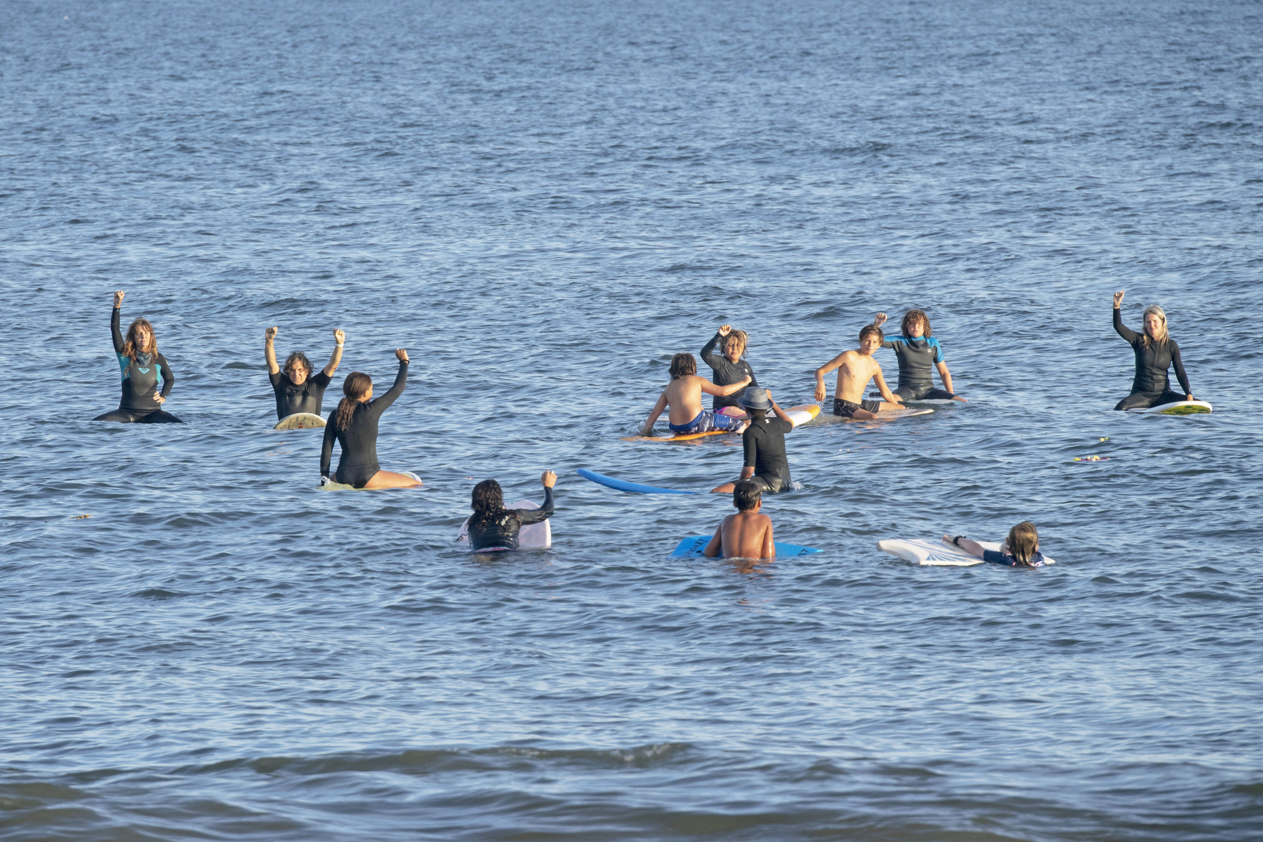 Paddlers raise their arms in solidarity while out on the water during the Paddle Out in Solidarity event in support of  Black Lives Matter on the beach at the end of Napeague Lane in Amagansett on August 26.    MICHAEL HELLER