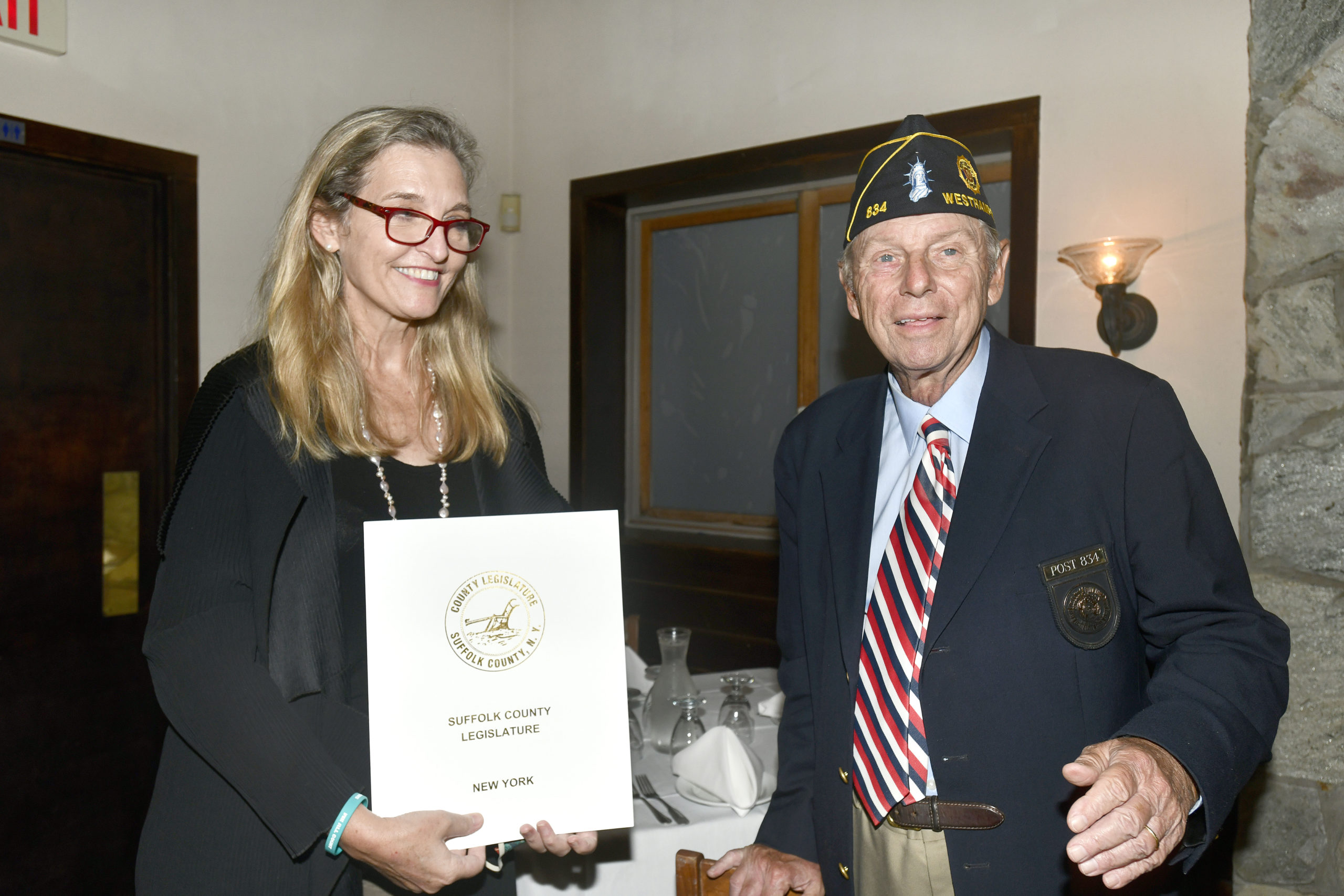Irene Donohue from Suffolk County Legislator Bridget Fleming's office presents a proclamation to Tom Hadlock, Commander of the American Legion Arthur Ellis Hamm Post 834 in Westhampton, in honor of the post's 100th anniversary on Thursday, September 17, at the Baby Moon restaurant. DANA SHAW
