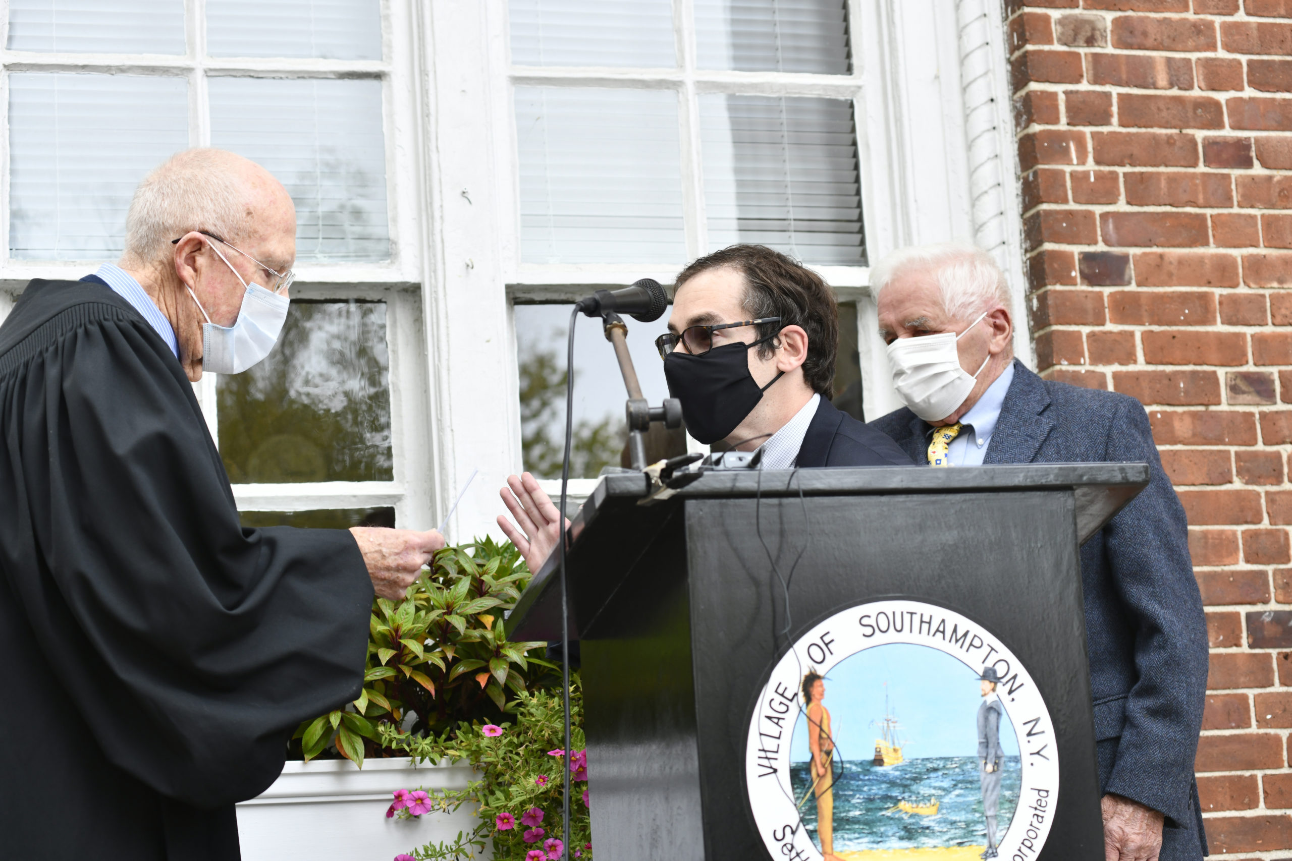 Joseph McLoughlin is sworn in on the steps of Southampton Villag Hall by Judge Michael Solomon while his father, former village trusteeJoseph McLoughlin looks on.  DANA SHAW