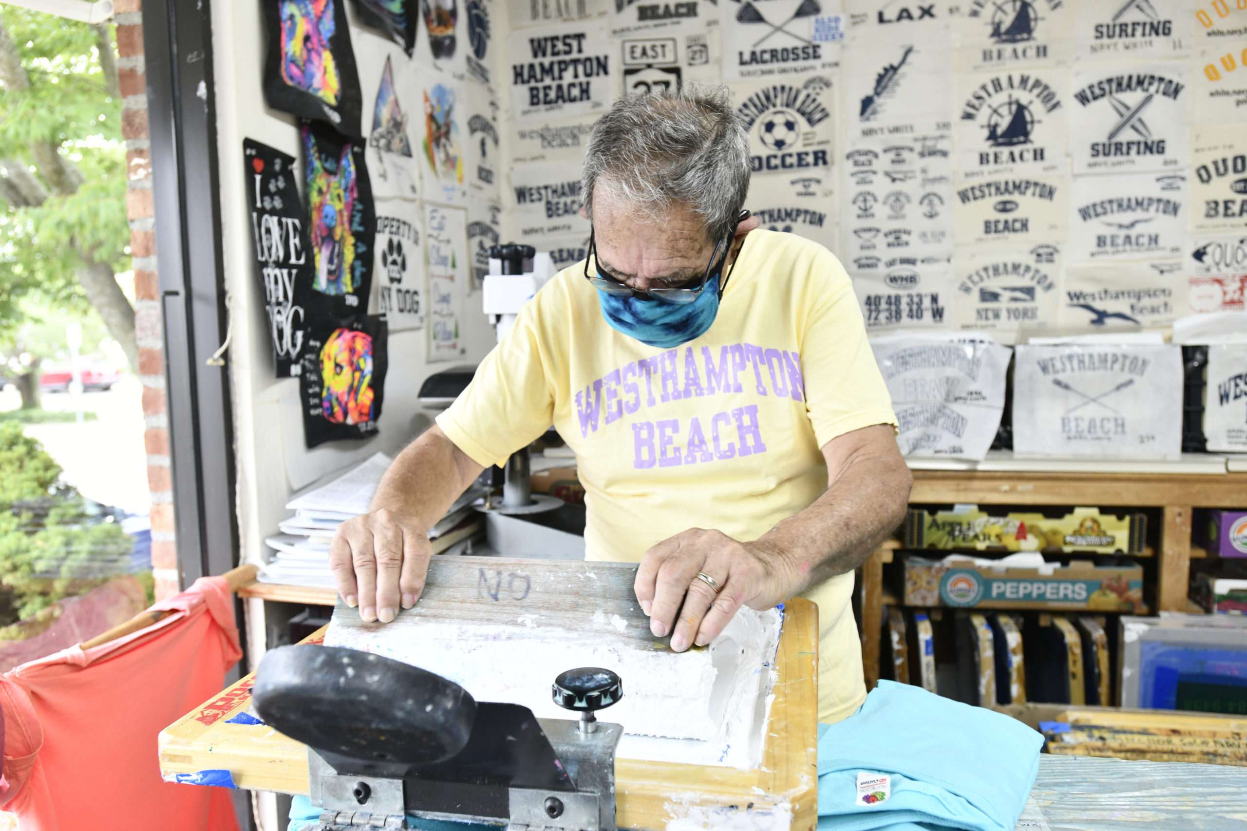 Jim Flood screens a t-shirt in his store in Westhampton Beach.   DANA SHAW