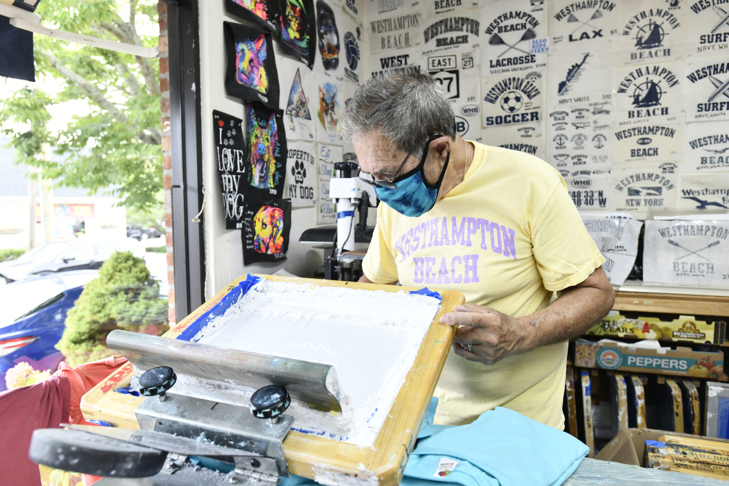 Jim Flood screens a t-shirt in his store in Westhampton Beach.   DANA SHAW