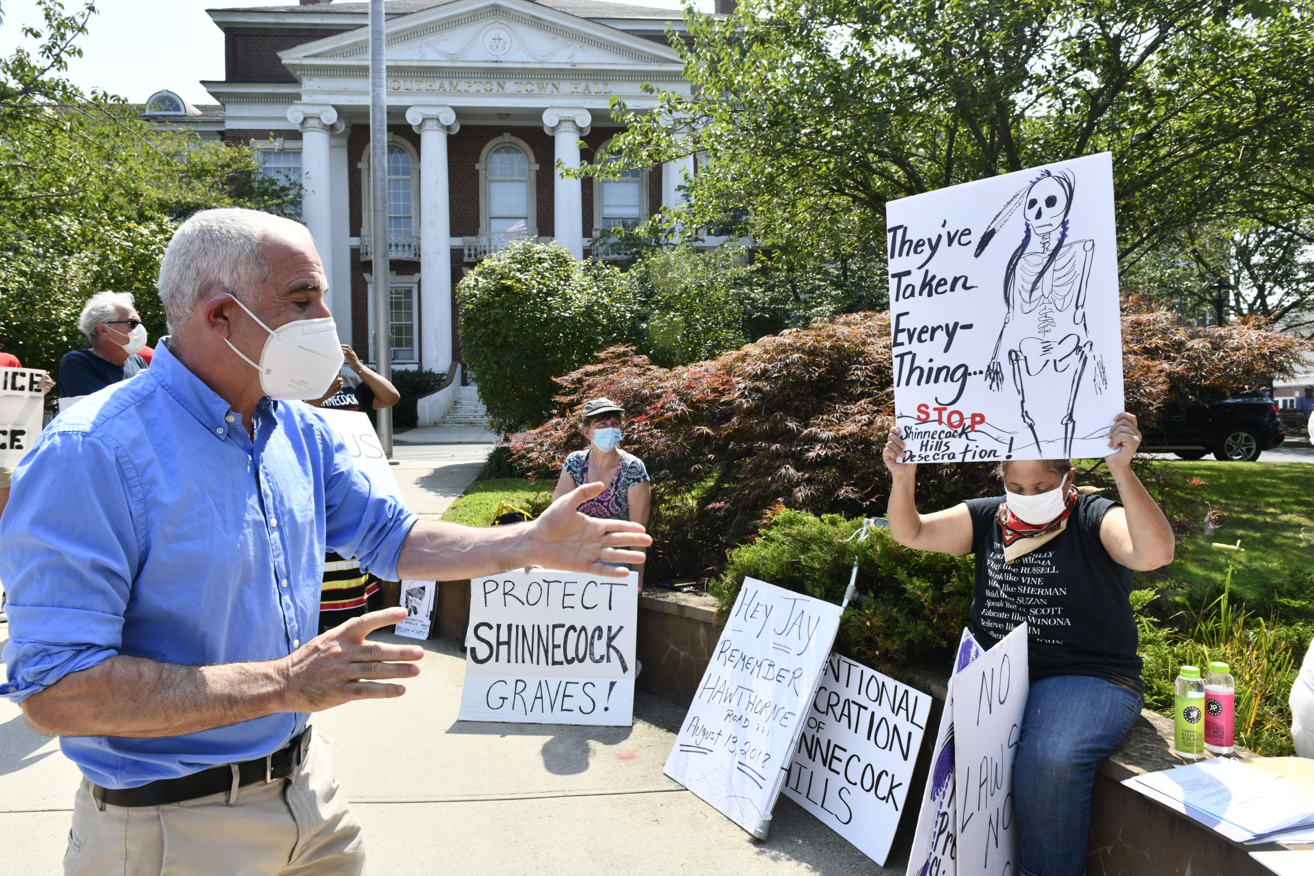 Protesters confronted Southampton Town Supervisor Jay Schneiderman in front of Town Hall in late August about creating legislation for graves protection.  DANA SHAW