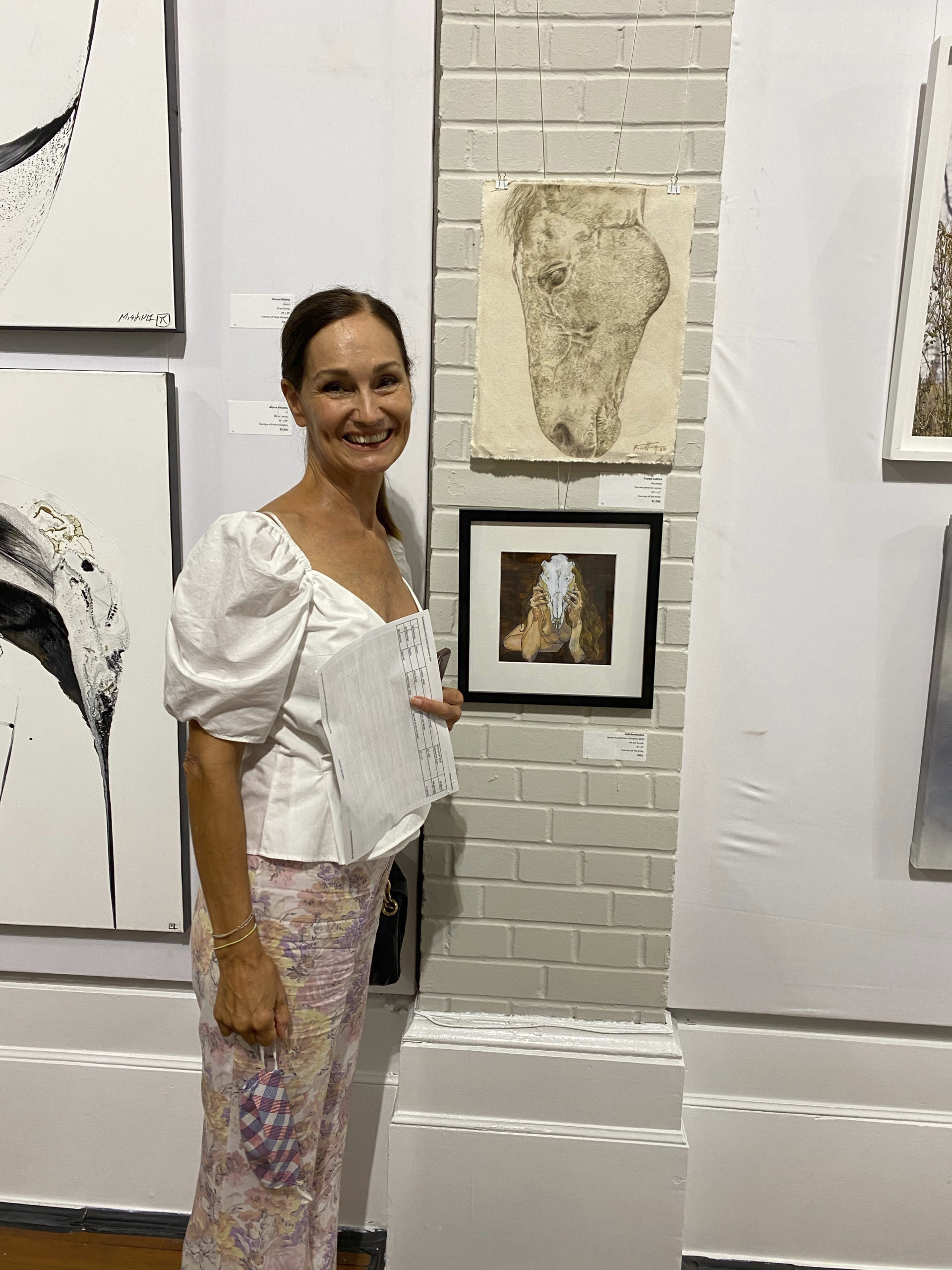 Ruth Cuttica standing in front of one of her sons donated art pieces.