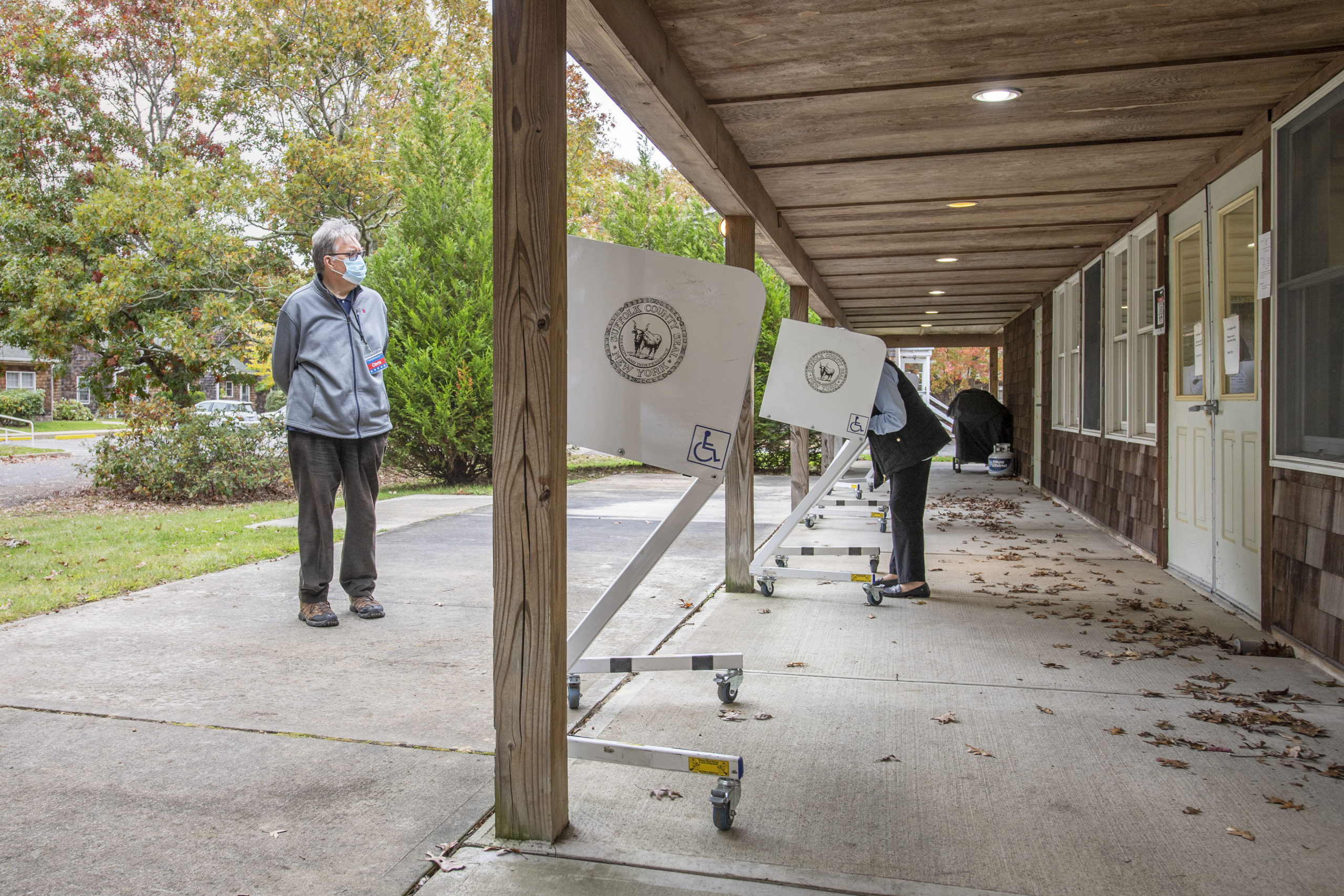A polling inspector keeps a watchful eye as voters cast their ballots as part of Early Voting in East Hampton Town at the Windmill Village complex on Accabonac Road on Monday morning.   MICHAEL HELLER