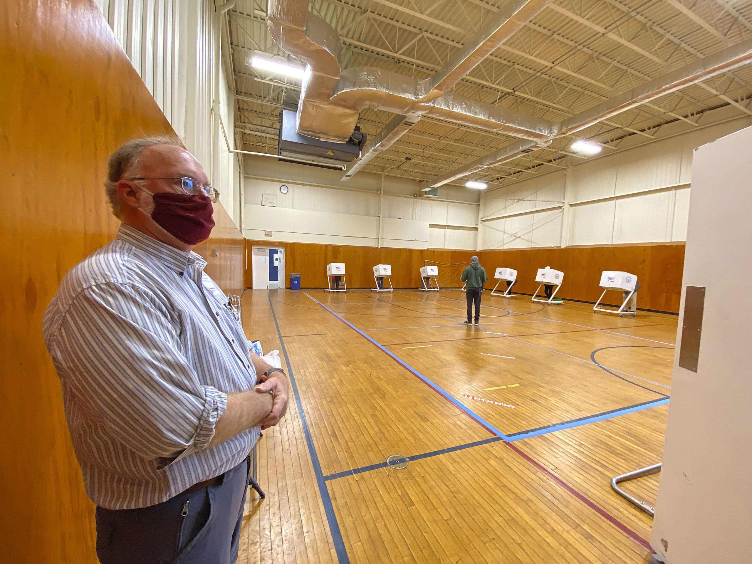 Board of Elections Inspector Charles Guthrie directs voters to booths at the Stony Brook Southampton gym on Monday.  DANA SHAW