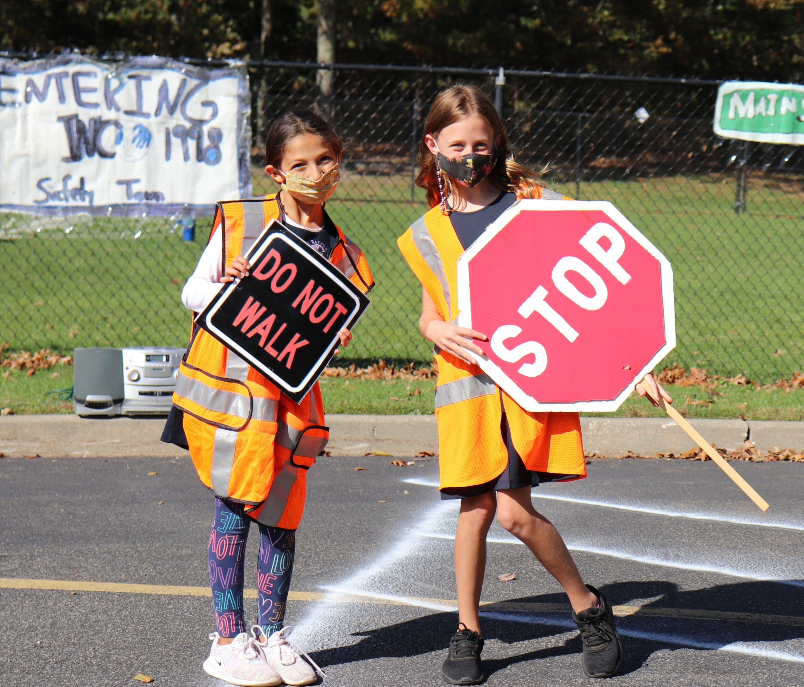 Sixth-grade students, Christina Nikolopoulos and Emery Liere, serve as crossing guards for the annual Tykes on Bikes Safety Town Event. 