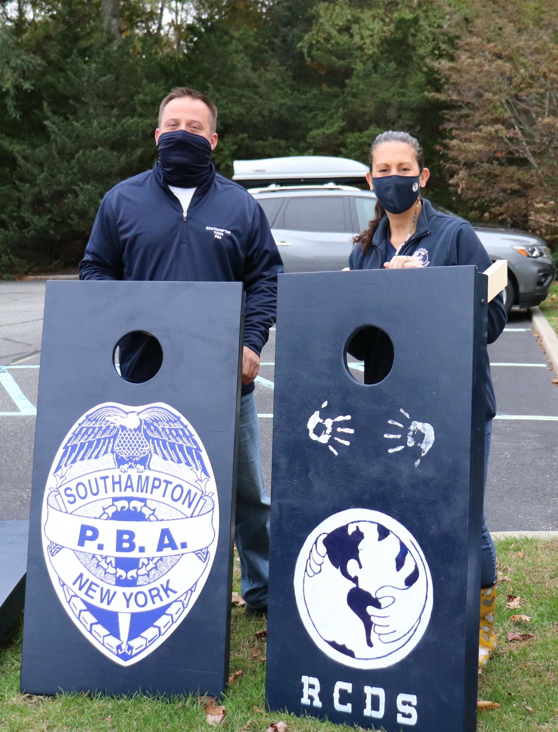Raynor Country Day School Principal Kerry Coonan and Southampton Town PBA President Erik Bretweiser with the school’s new cornhole boards. 
