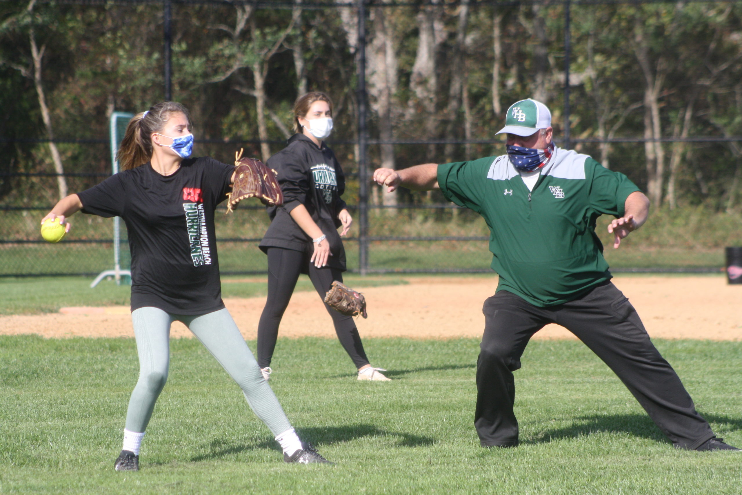 Westhampton Beach softball coach Jeff Doroski gives throwing instruction to Marcella Fitzgerald. CAILIN RILEY 