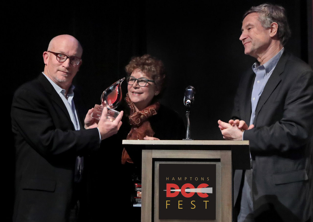 Director Alex Gibney at Bay Street Theater accepting the 2016 Hamptons Doc Fest Career Achievement Award from Jacqui Lofaro with Ron Simon.