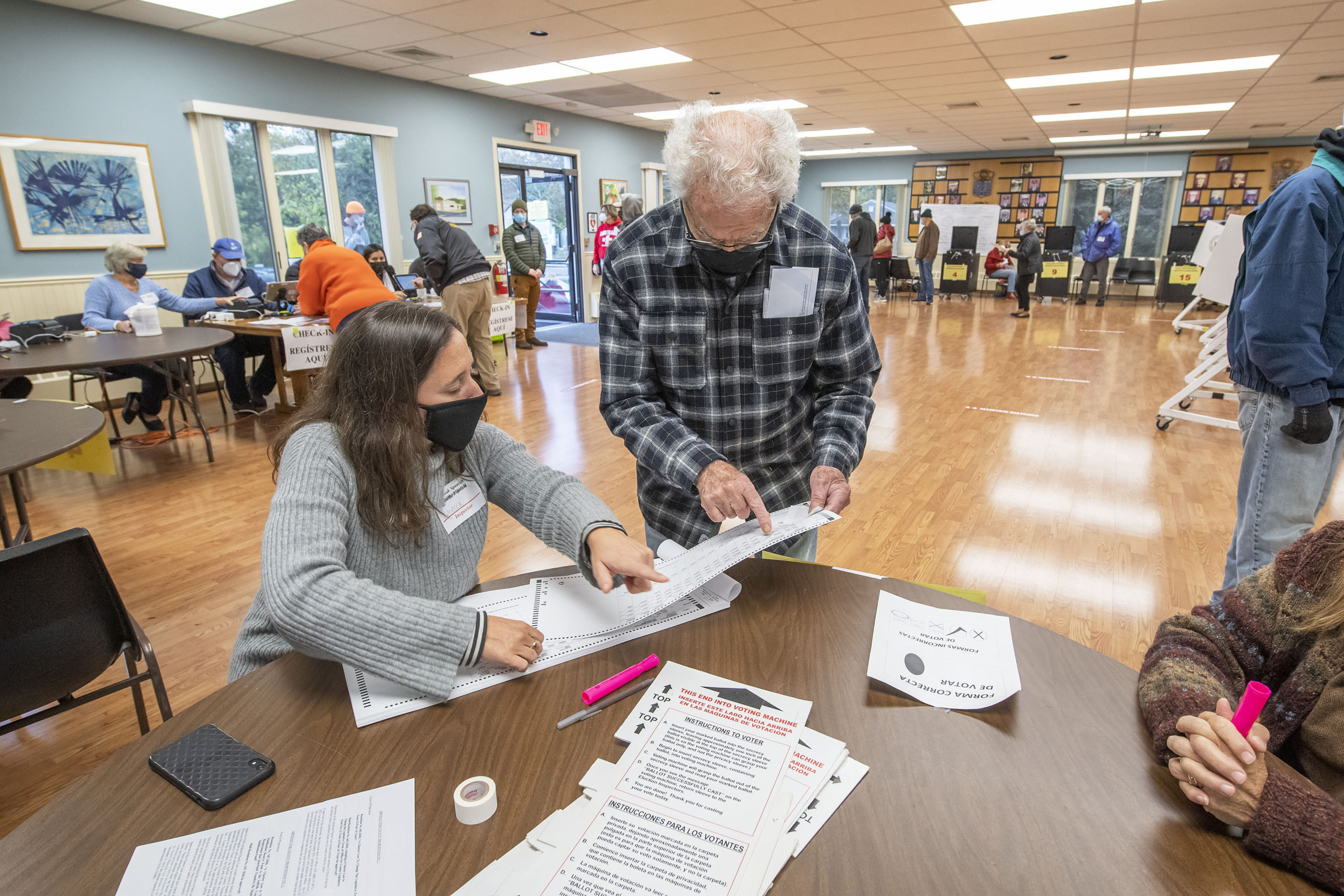 Poll Worker Rebecca Gordon helps a voter with his ballot at the polling station at the Springs firehouse on Election Day morning.   MICHAEL HELLER