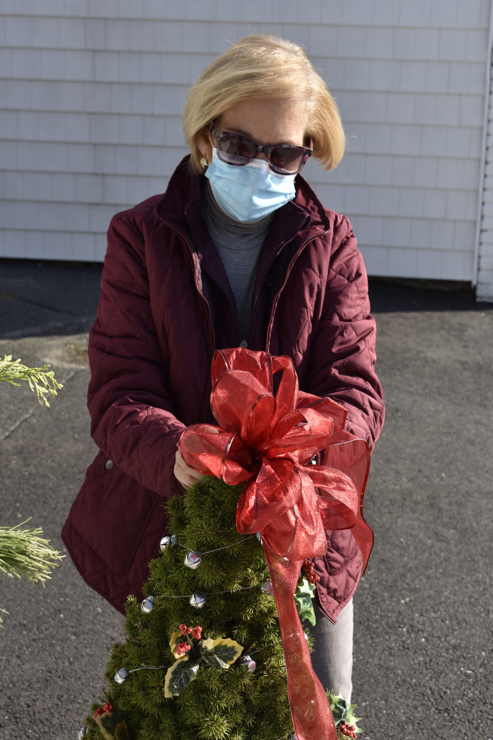 Barbara Evans decorates a tree on Eastport's Main Street.