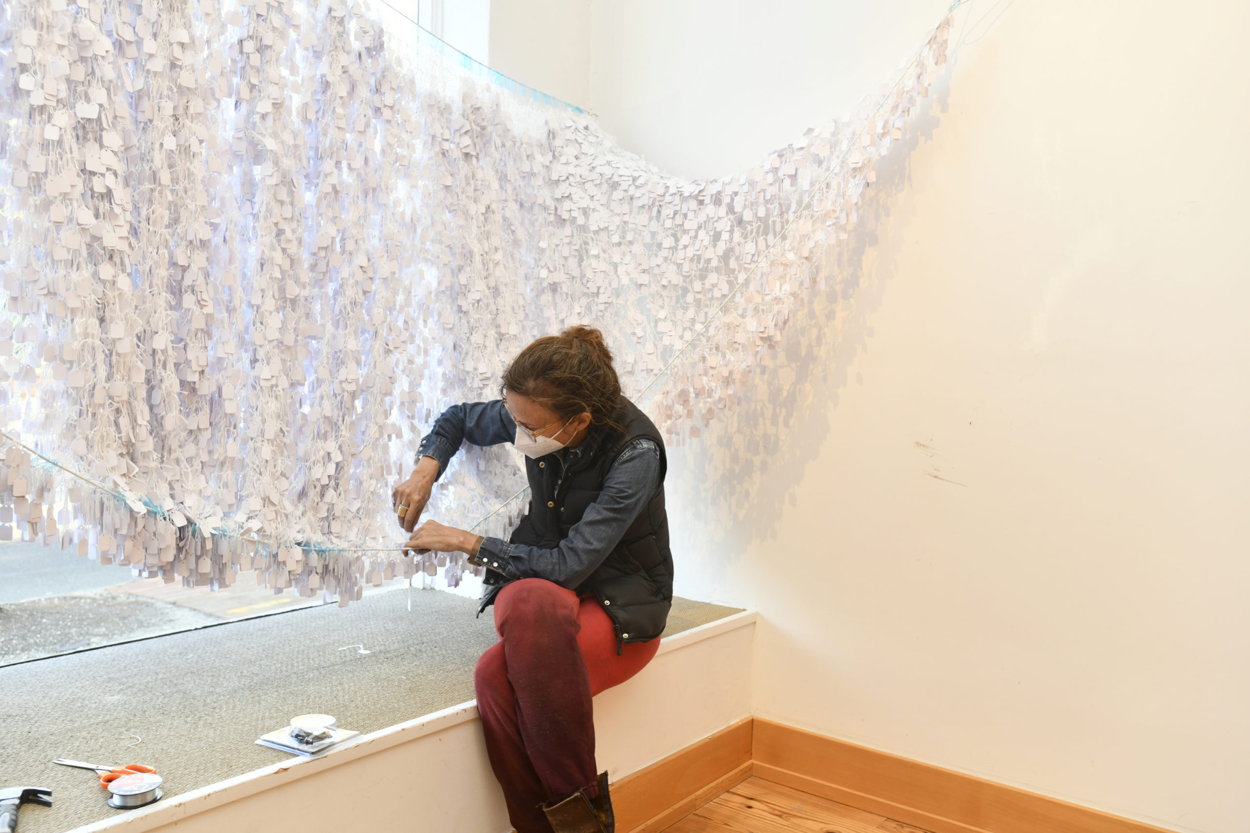 Artist Alice Hope works on installing her work 