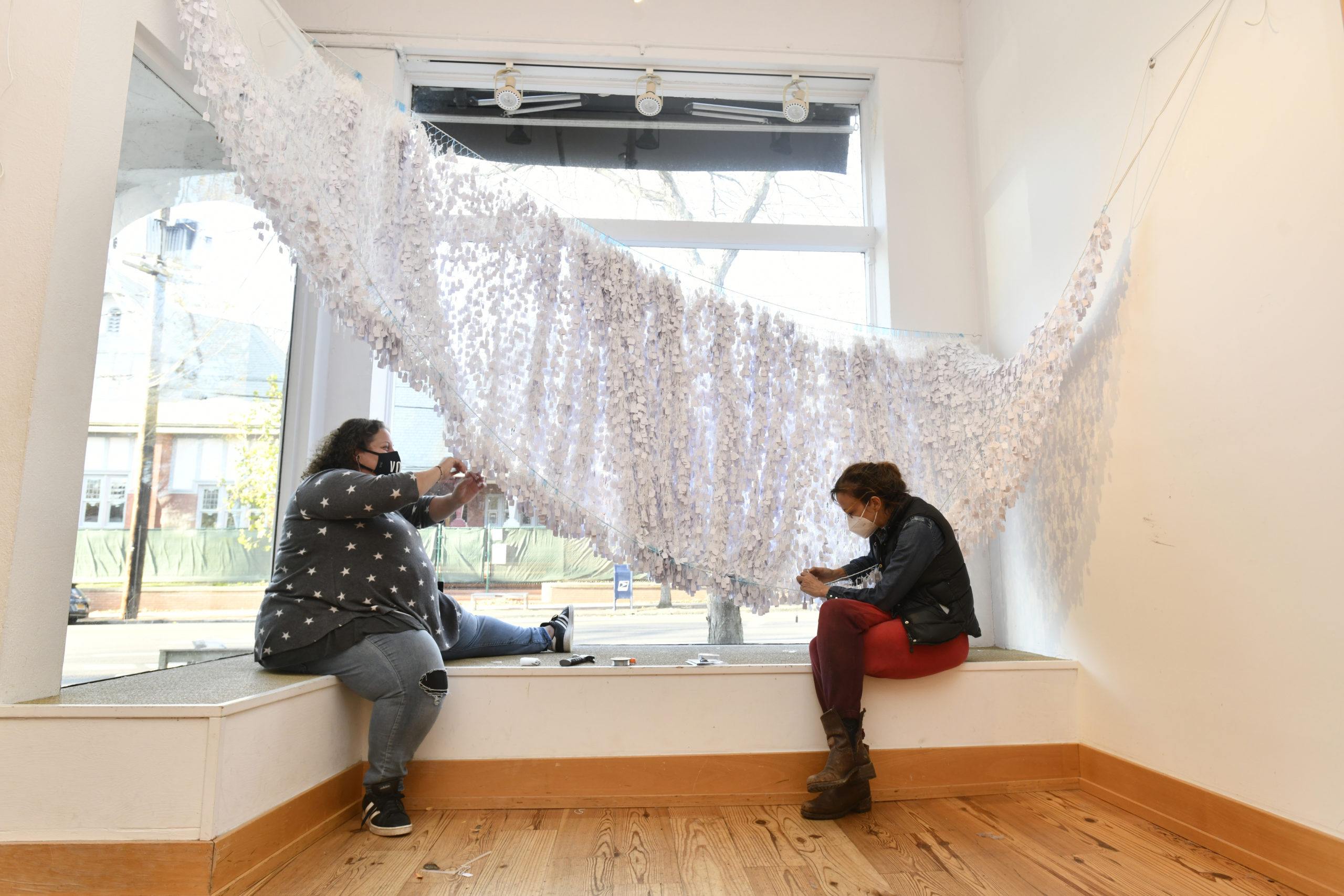 Southampton Arts Center Artistic Director Amy Kirwin and and artist Alice Hope work on installing Hope's work 