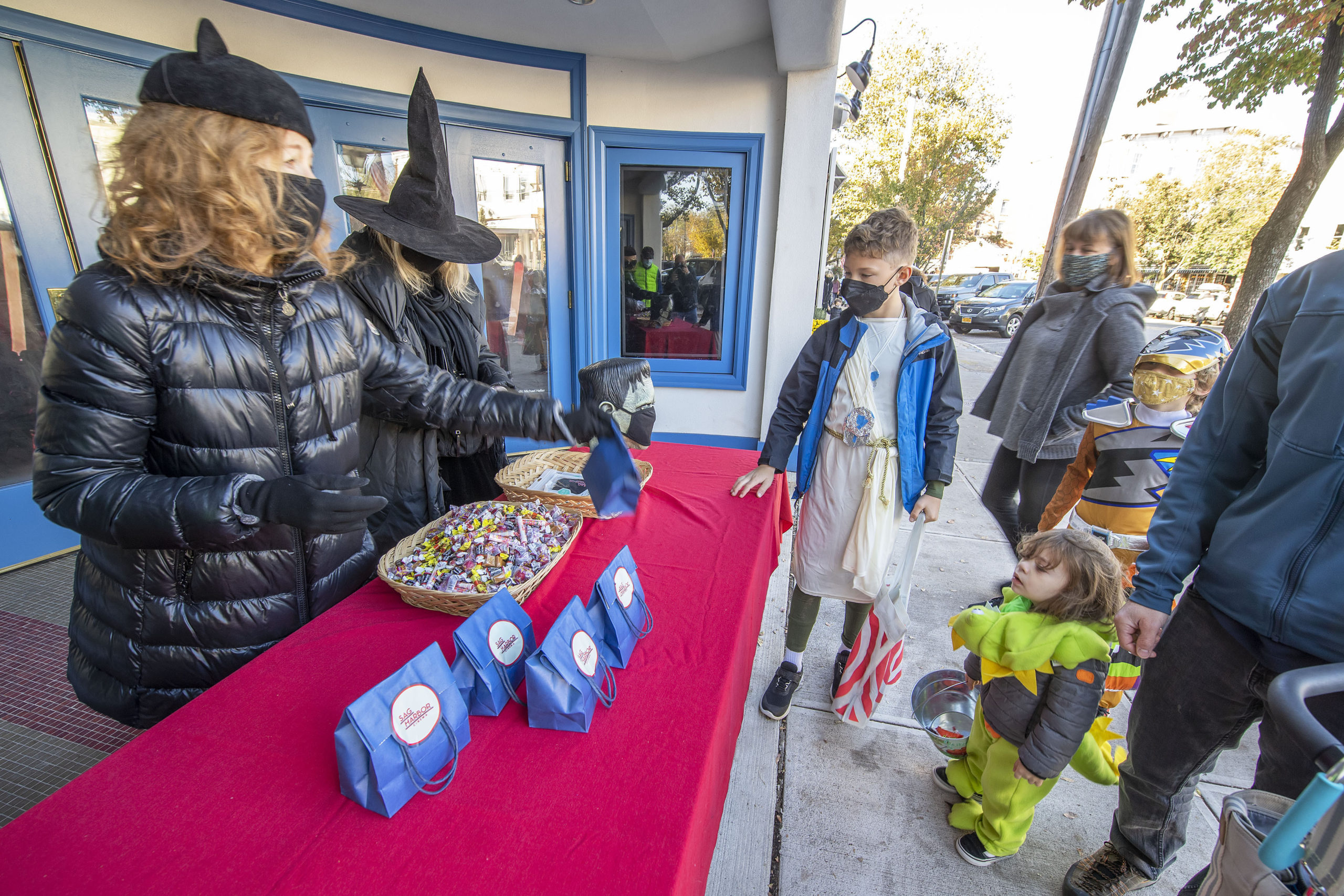 Costumed little ones stopped by the Sag Harbor Cinema to get some candy from April Gornik and Gail Bruesewitz on Halloween afternoon.    MICHAEL HELLER
